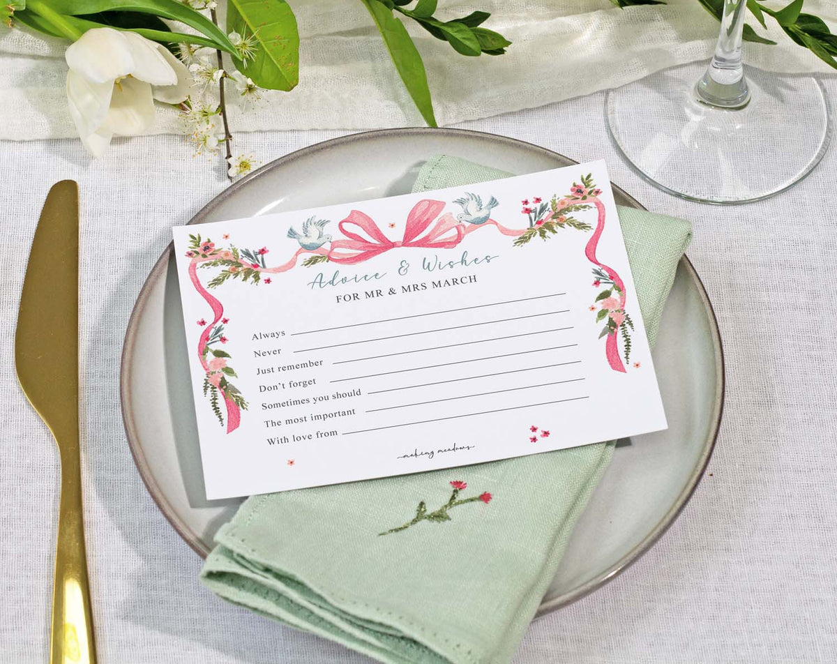 Vintage Wedding Advice Cards beautifully displayed on a table setting with floral accents and a green napkin.