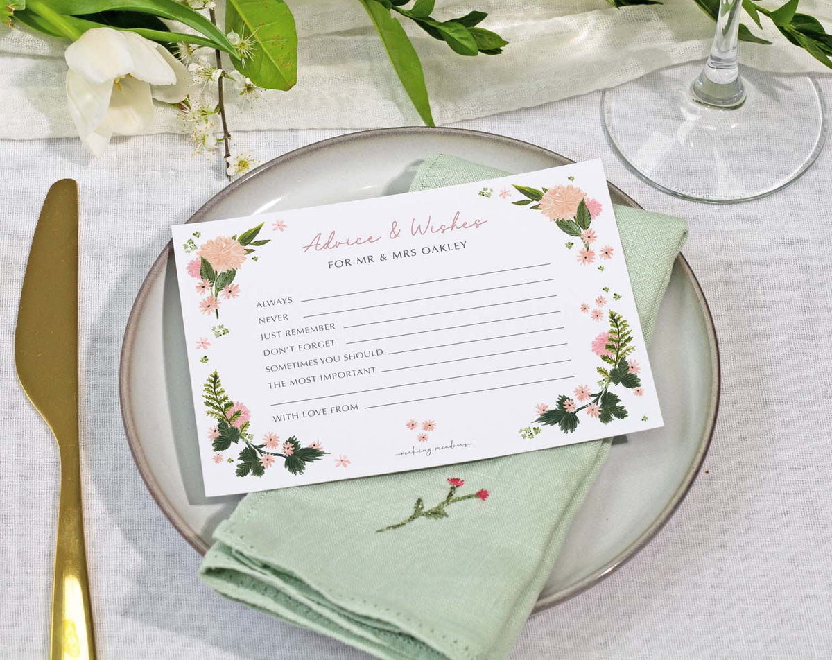 Pink Floral Wedding Advice Cards on a plate with a napkin, featuring spaces for advice and wishes for the newlyweds.