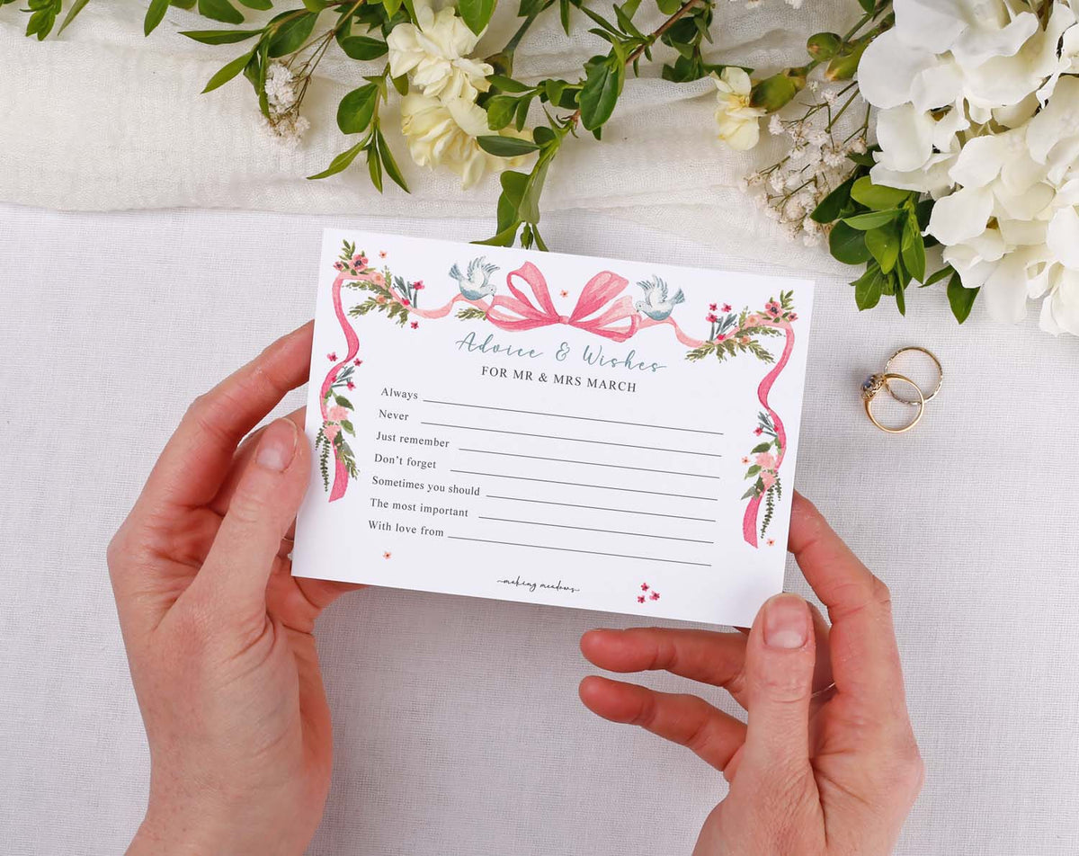 Vintage Wedding Advice Cards held by hands with floral design and space for guest messages and wishes.