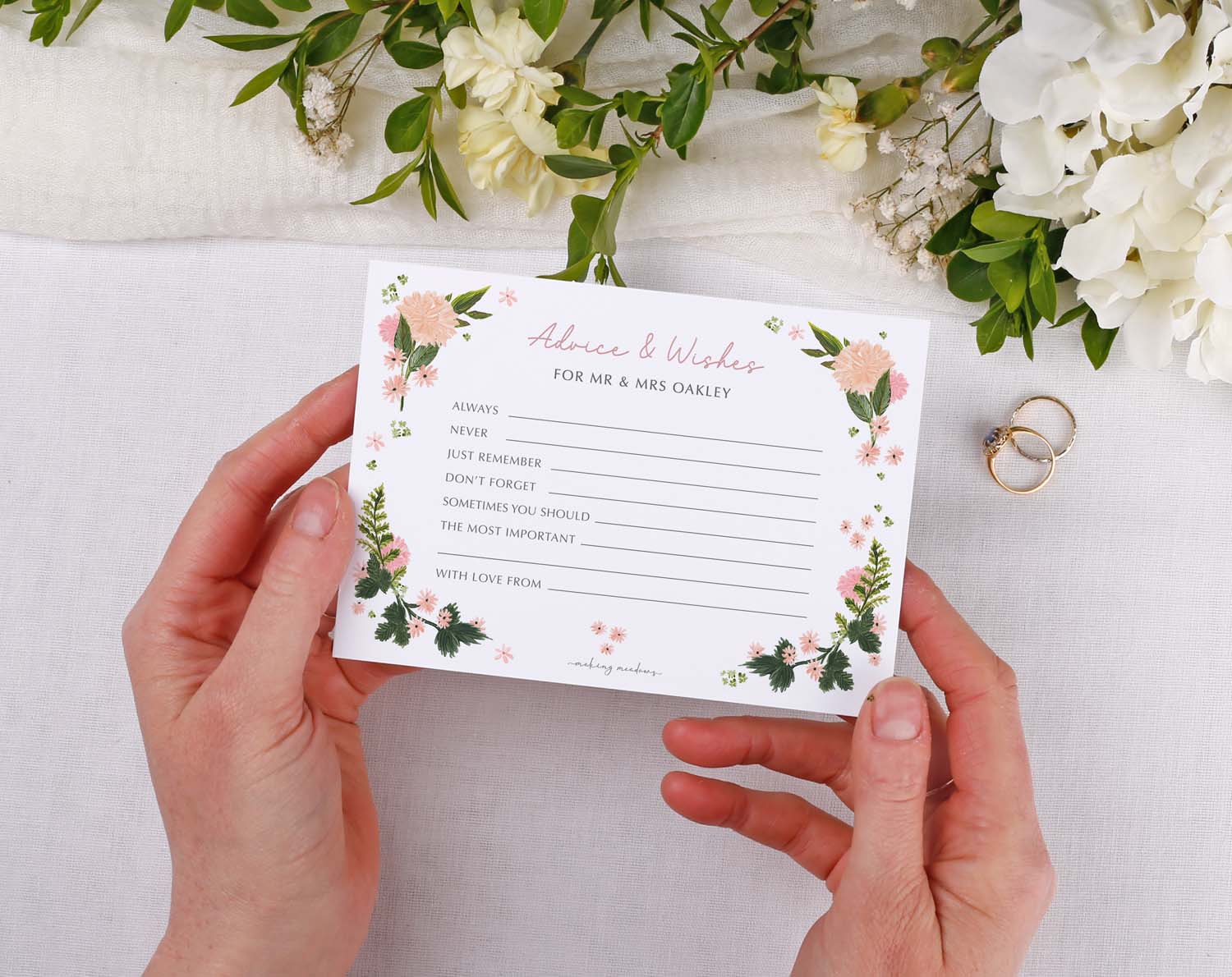 Person holding Pink Floral Wedding Advice Cards for guests to share messages and advice.