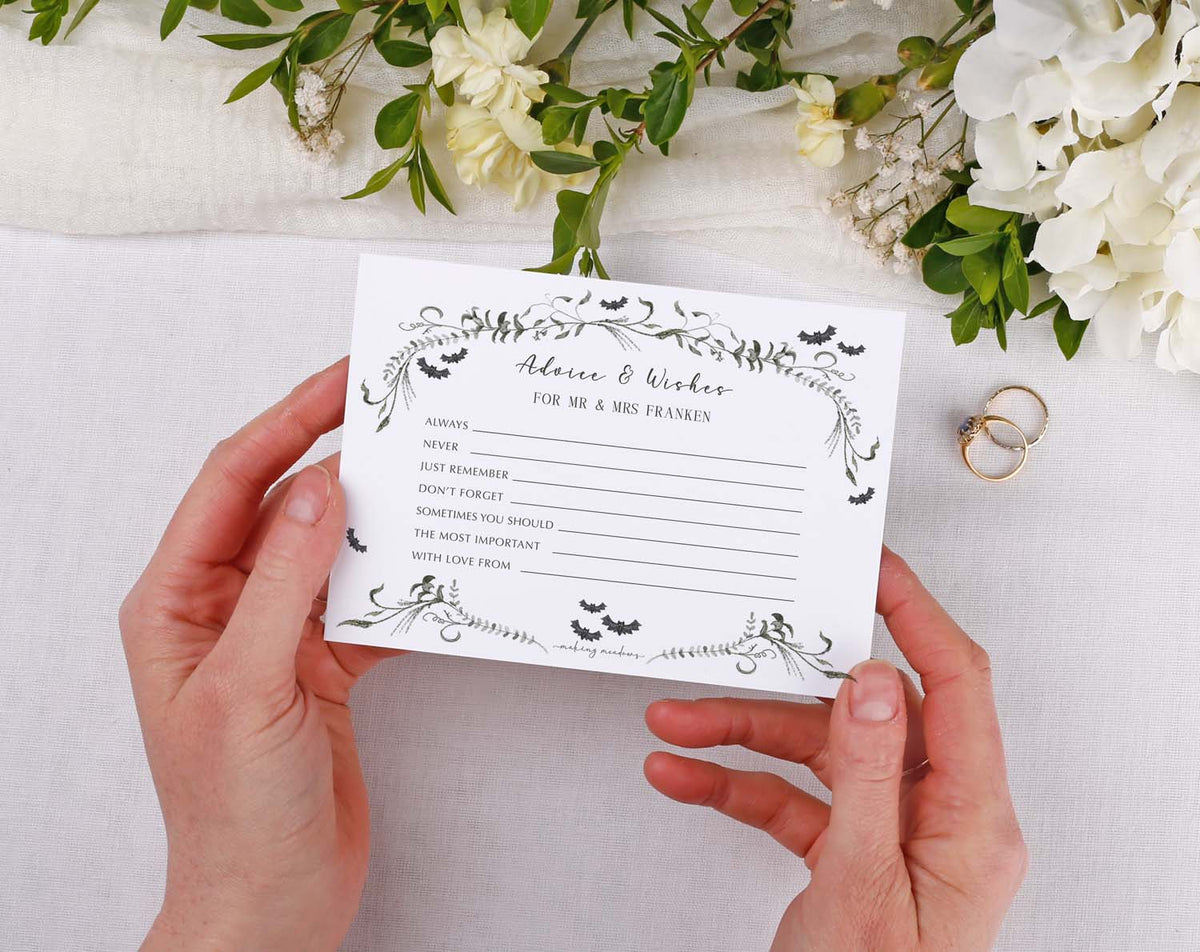 Gothic Wedding Advice Cards displayed in hands with floral decor and wedding rings, ideal for guest wishes and keepsakes.