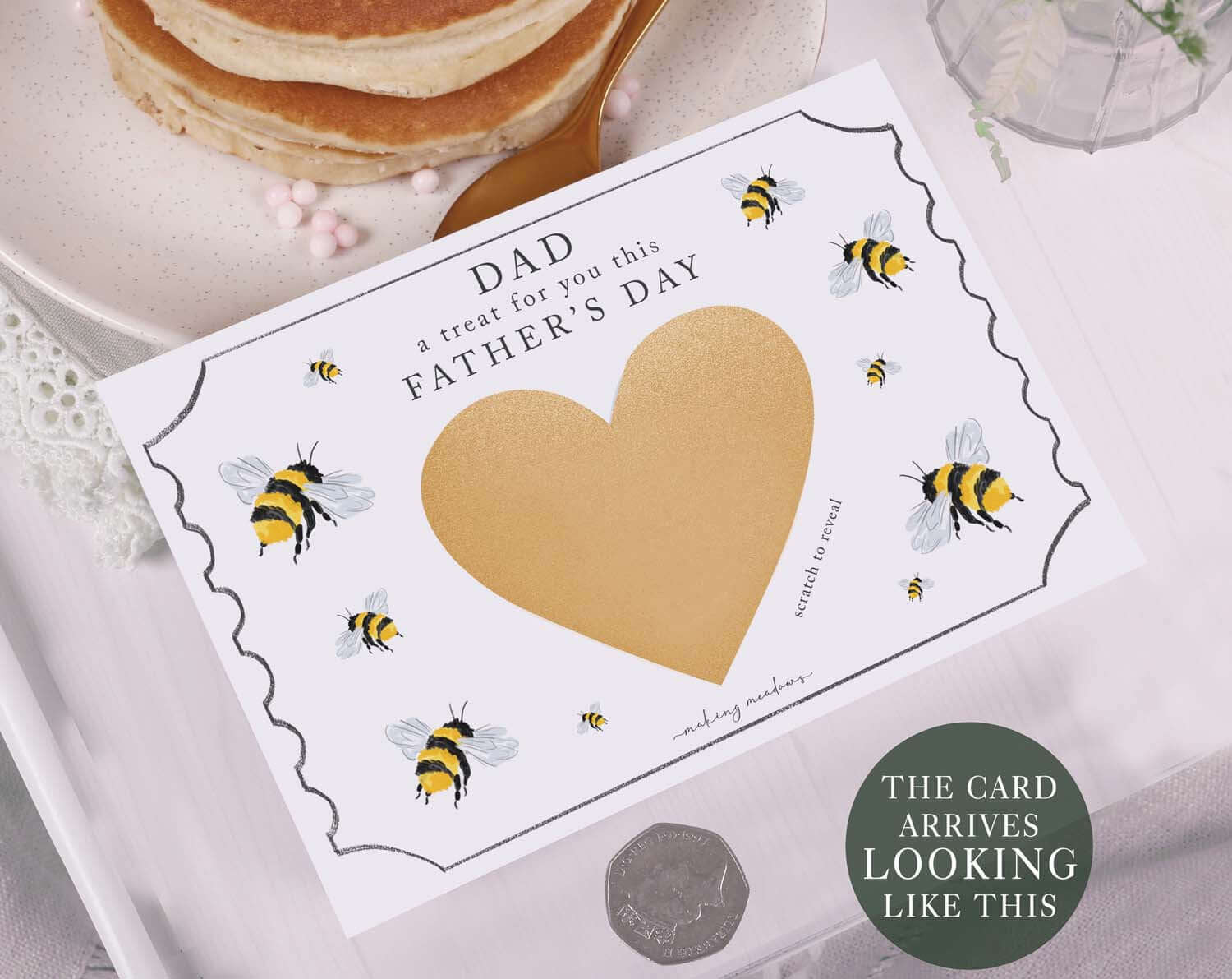 Bee Scratch To Reveal Card For Dad displayed with bumble bee design and gold heart scratch area on a table.