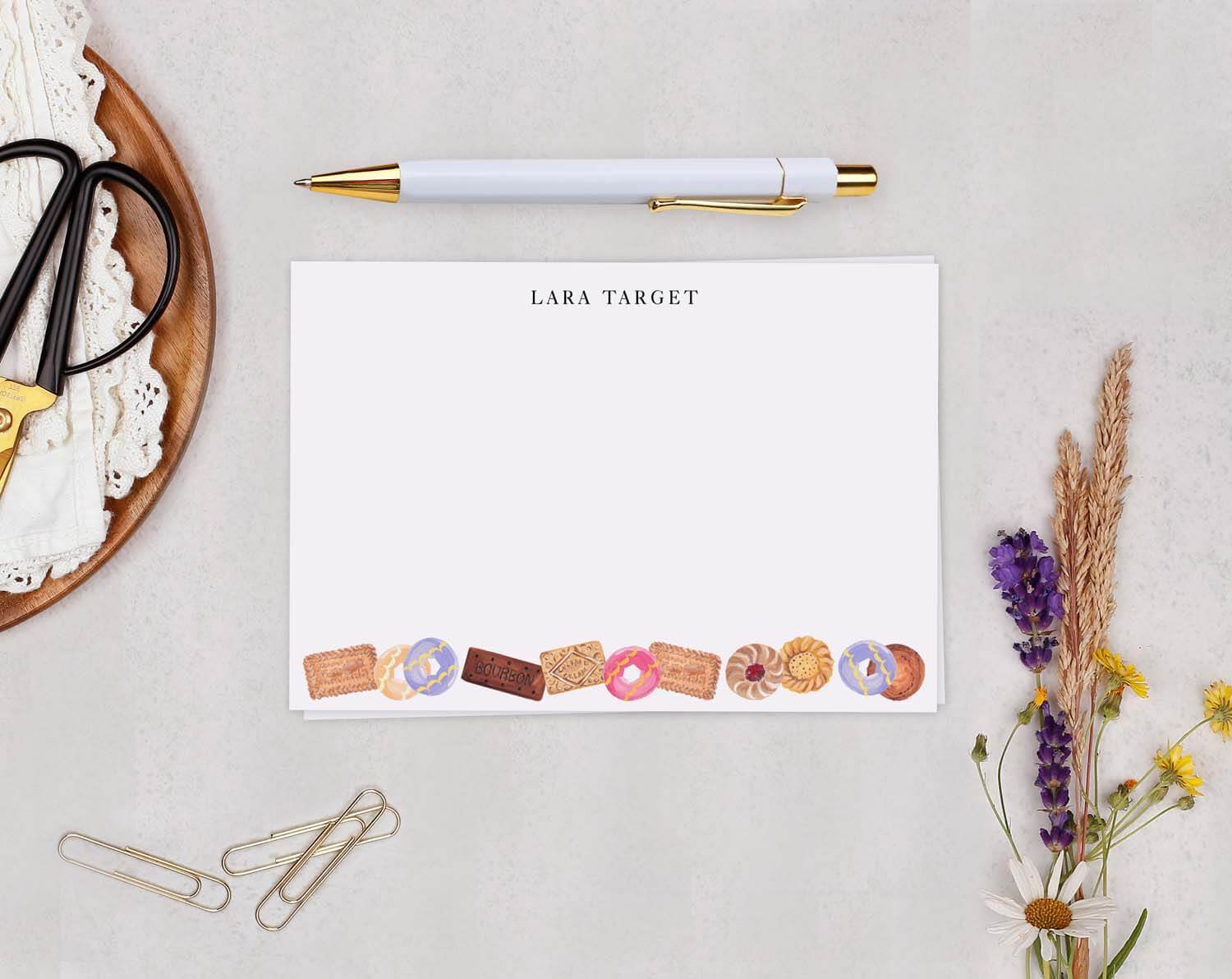 Biscuit Personalised Note Cards featuring charming biscuit illustrations on a notecard with a pen and stationery.