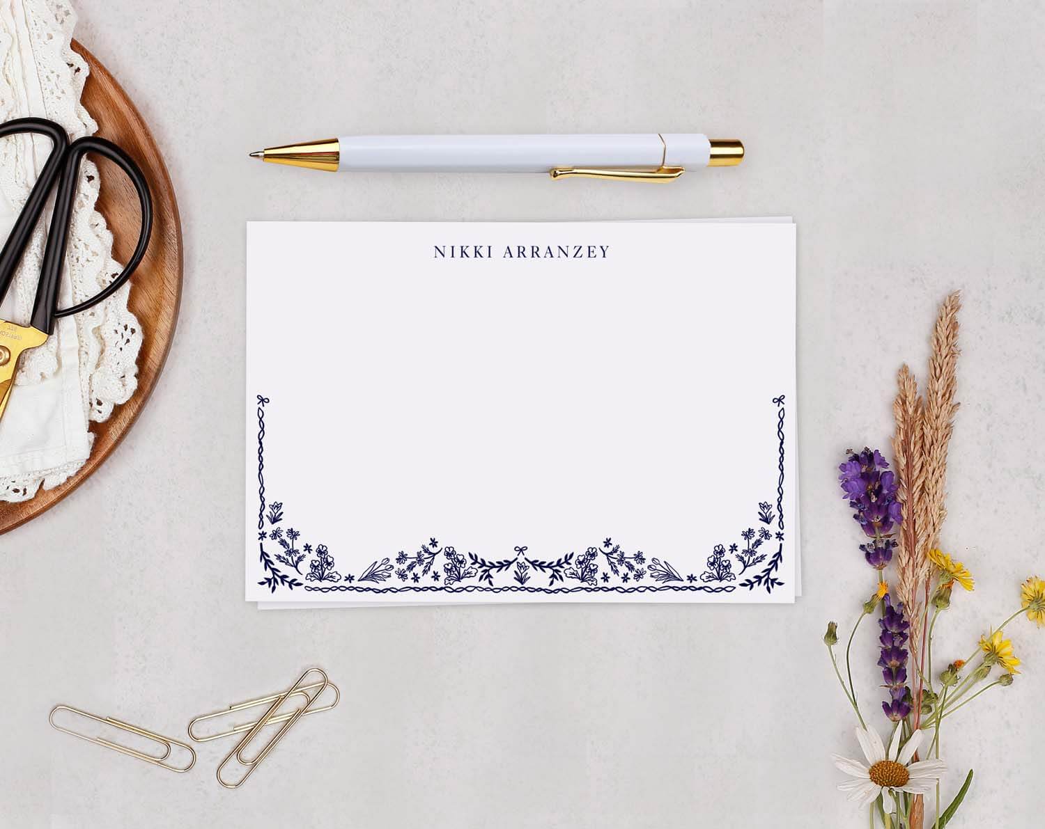 Blue Floral Personalised Note cards on a table with scissors, a pen, and flowers.