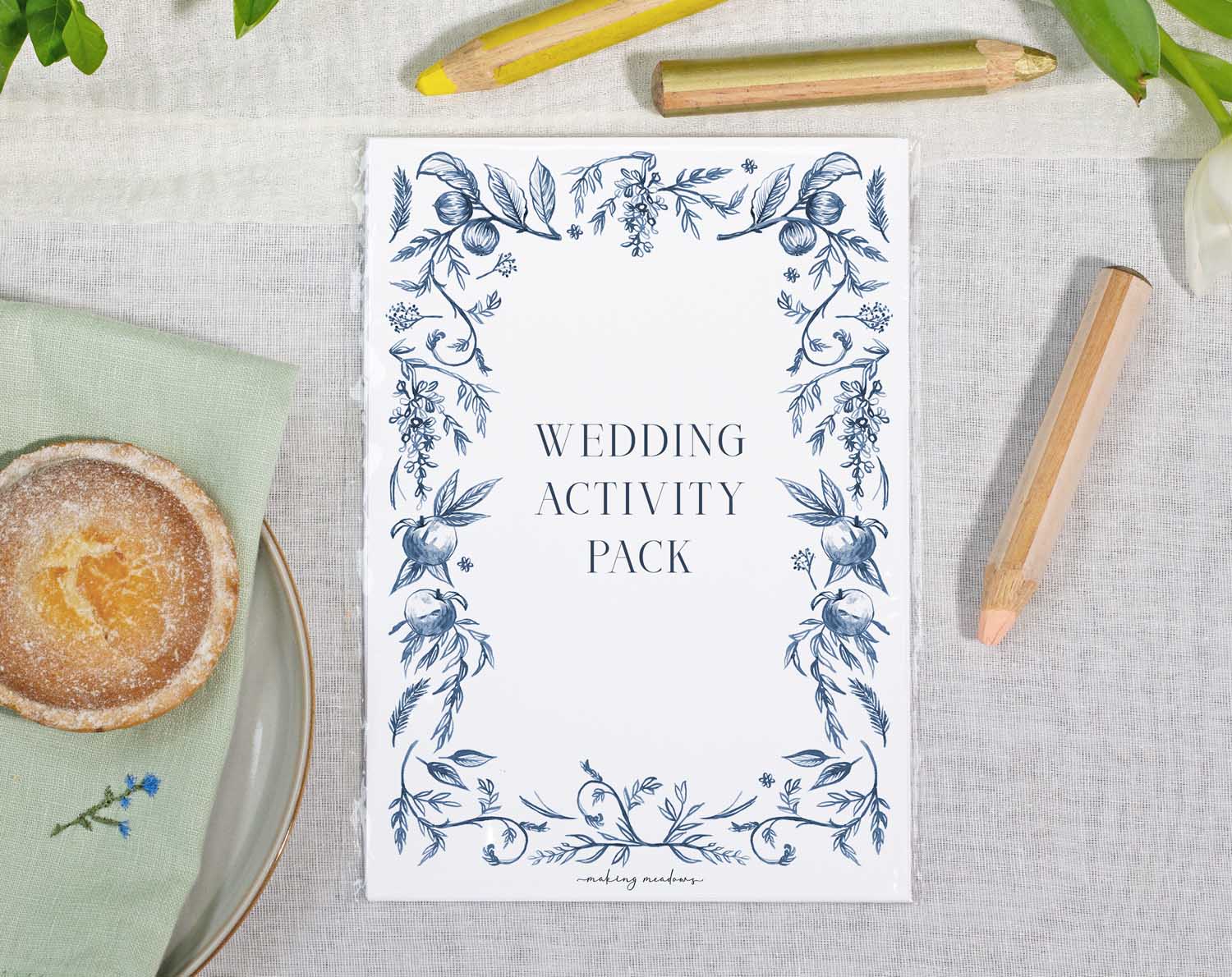 Blue Garden Wedding Kids Activity Pack displayed on a table with floral design and colored pencils.