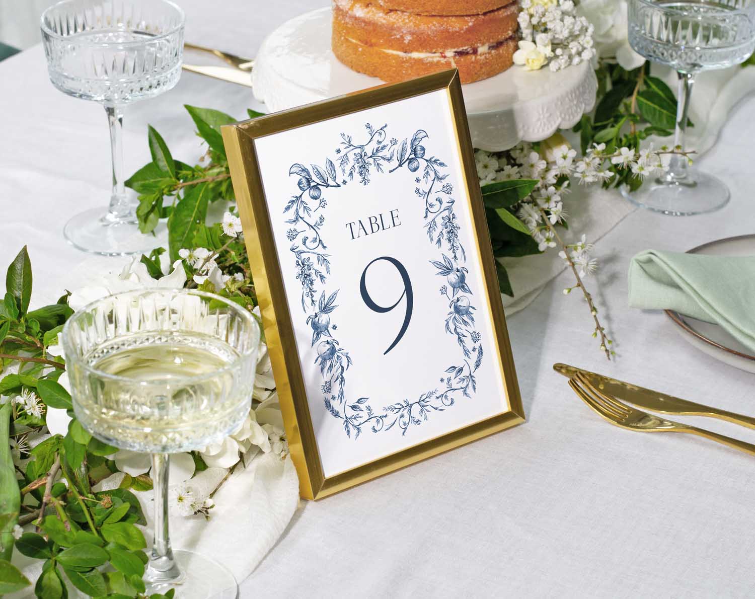 Blue Garden Wedding Table Numbers featuring table 9 with navy blue botanicals in a gold frame on a styled reception table.