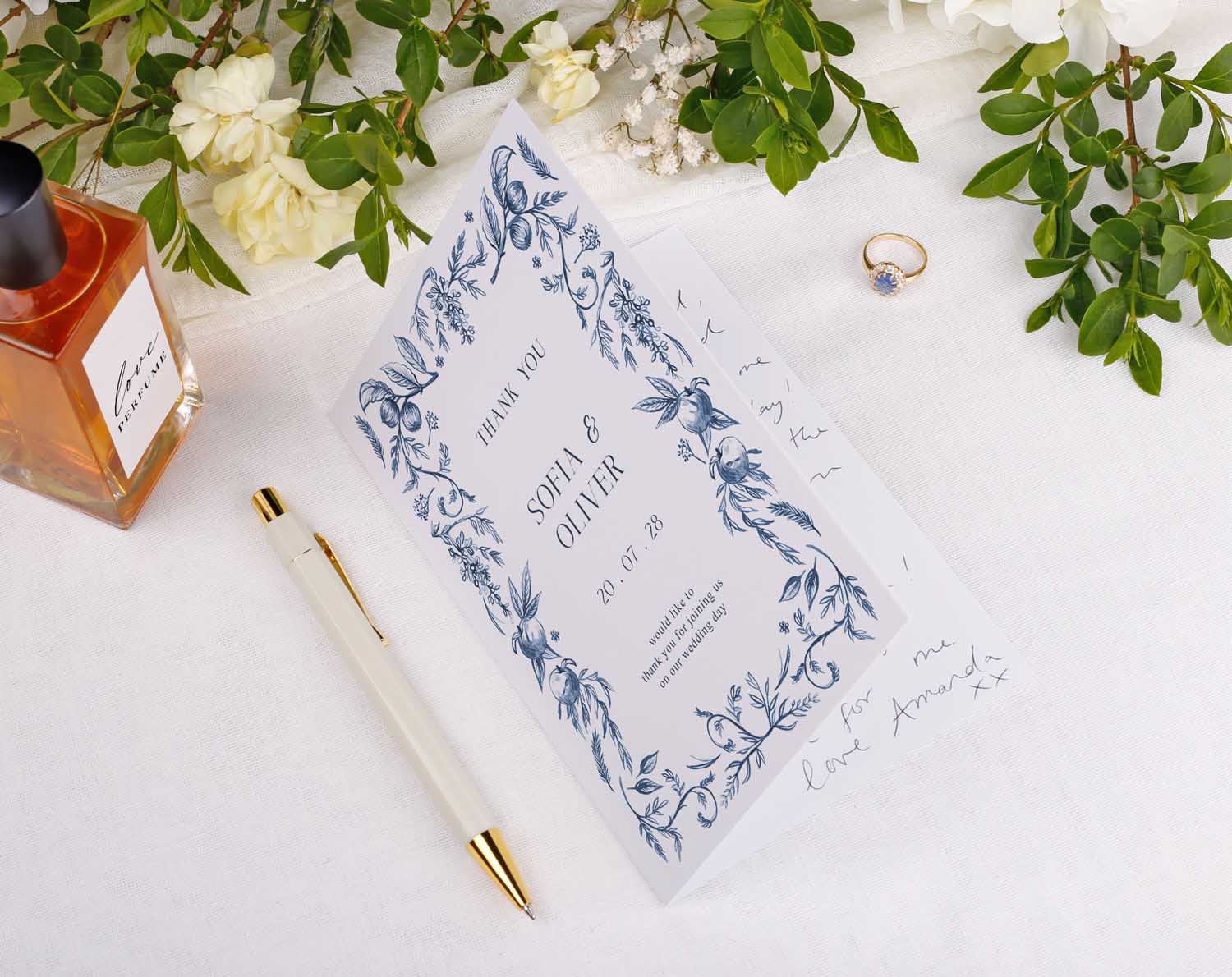 Blue Garden Wedding Thank You Cards featuring floral design, elegant pen, and ring on floral table setting.