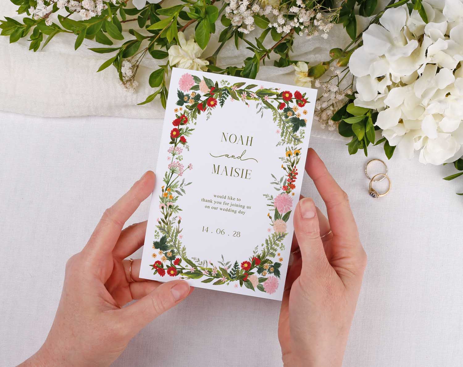 A person holding Boho Wedding Thank You Cards surrounded by greenery and flowers, perfect for expressing gratitude.