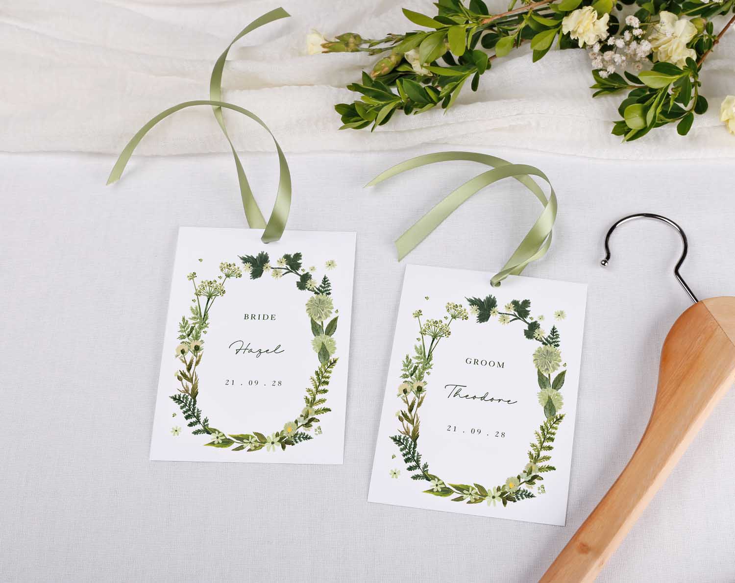 Botanical Wedding Hanger Tags decorated with greenery and ribbons for bride and groom, perfect for weddings.