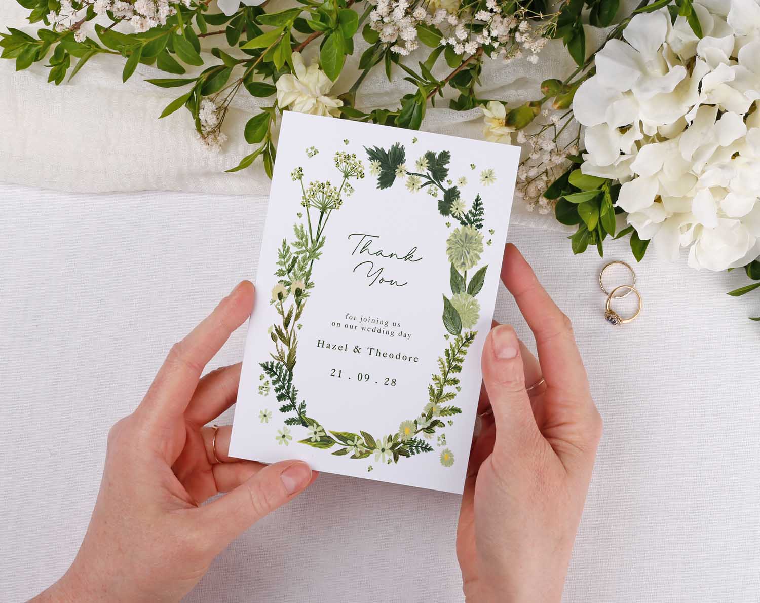 Botanical Wedding Thank You Cards held in hands, featuring floral design and personalized details.