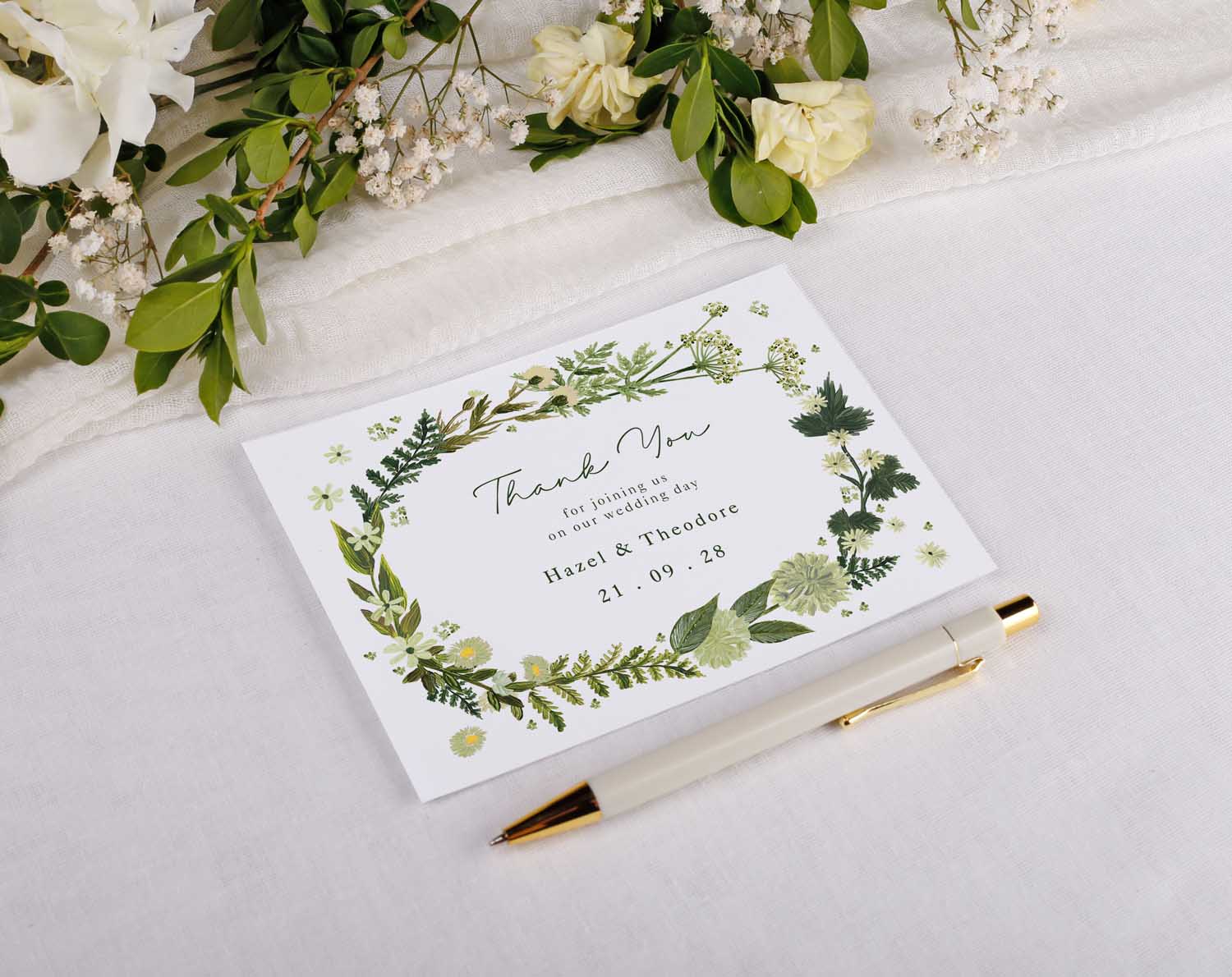Botanical Wedding Thank You Postcards with floral design and pen on white background.