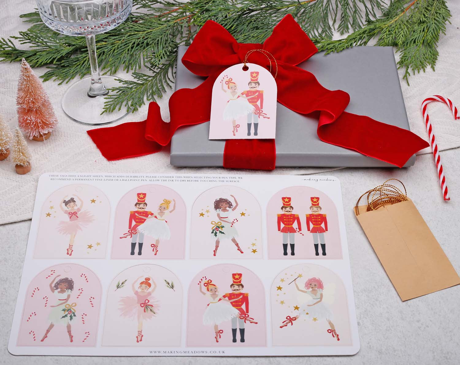 Nutcracker Christmas Gift Tags on gift box with red ribbon, featuring ballet dancer designs and festive decorations.