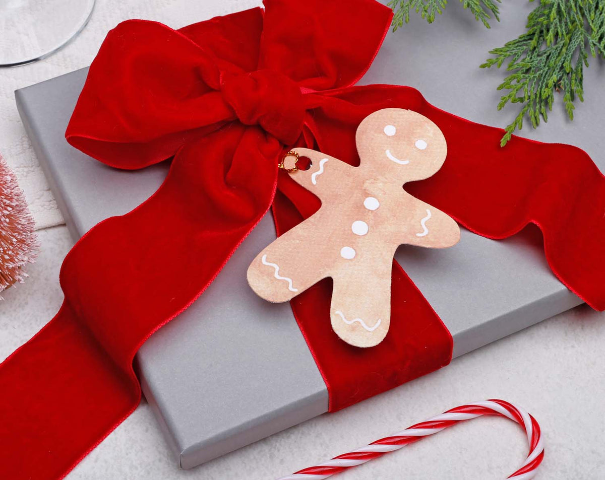 Gingerbread Christmas Gift Tags on a beautifully wrapped present with a red bow, adding festive charm to holiday gifts.
