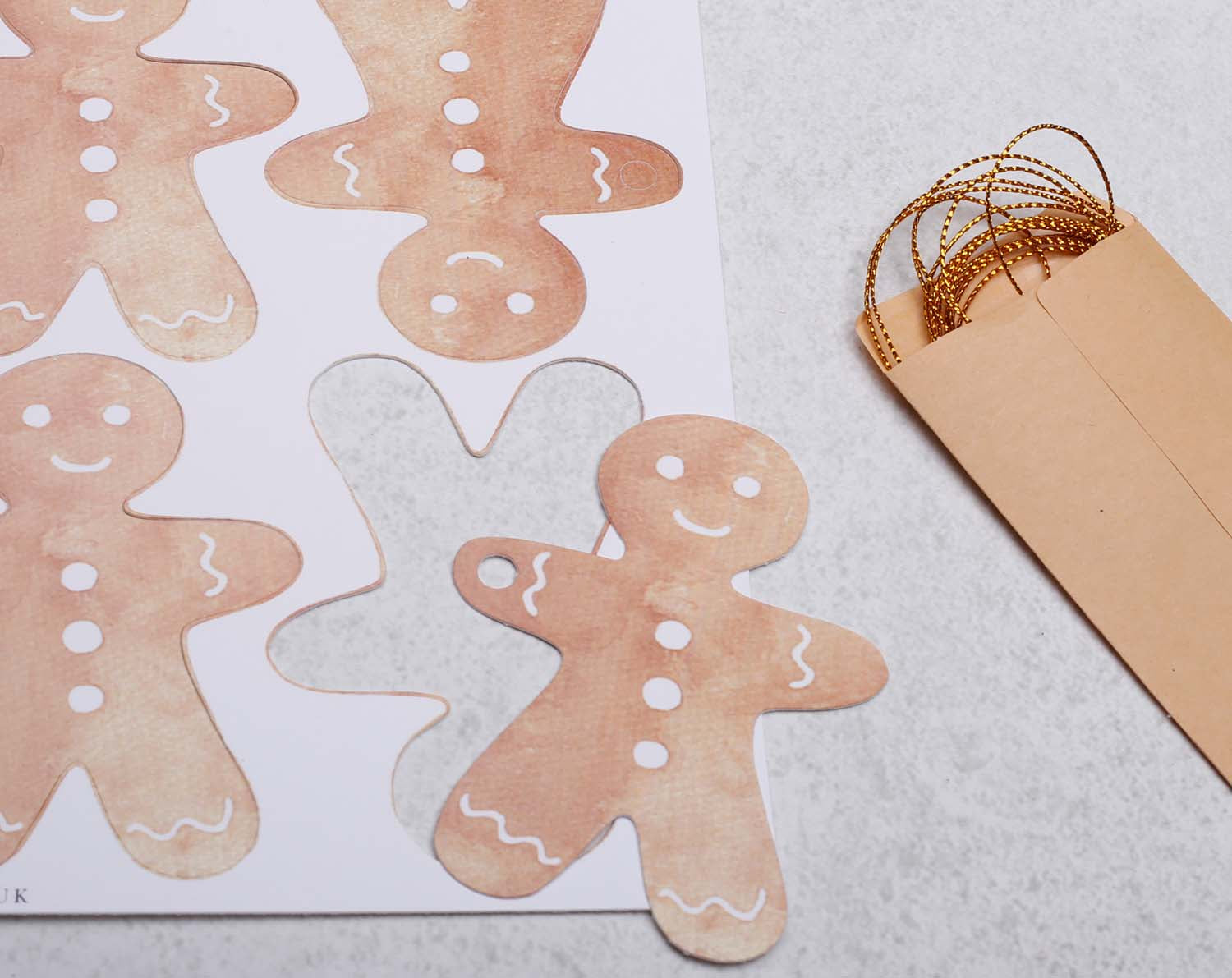 Gingerbread Christmas Gift Tags - 16 Pack featuring cute gingerbread man designs with gold strings and envelopes.