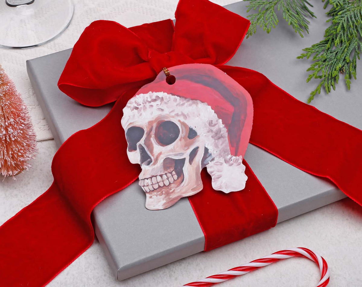 Skull Christmas Gift Tags - 12 Pack on a silver present with red ribbon, adding a gothic touch to holiday gifts.