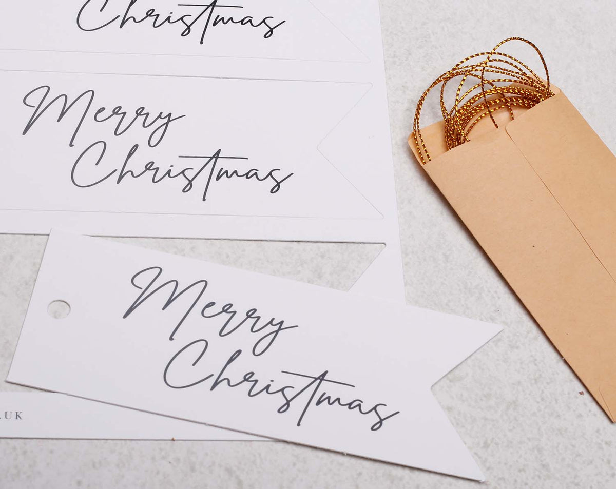 Merry Christmas Gift Tags featuring elegant typography with an envelope and golden string decoration.
