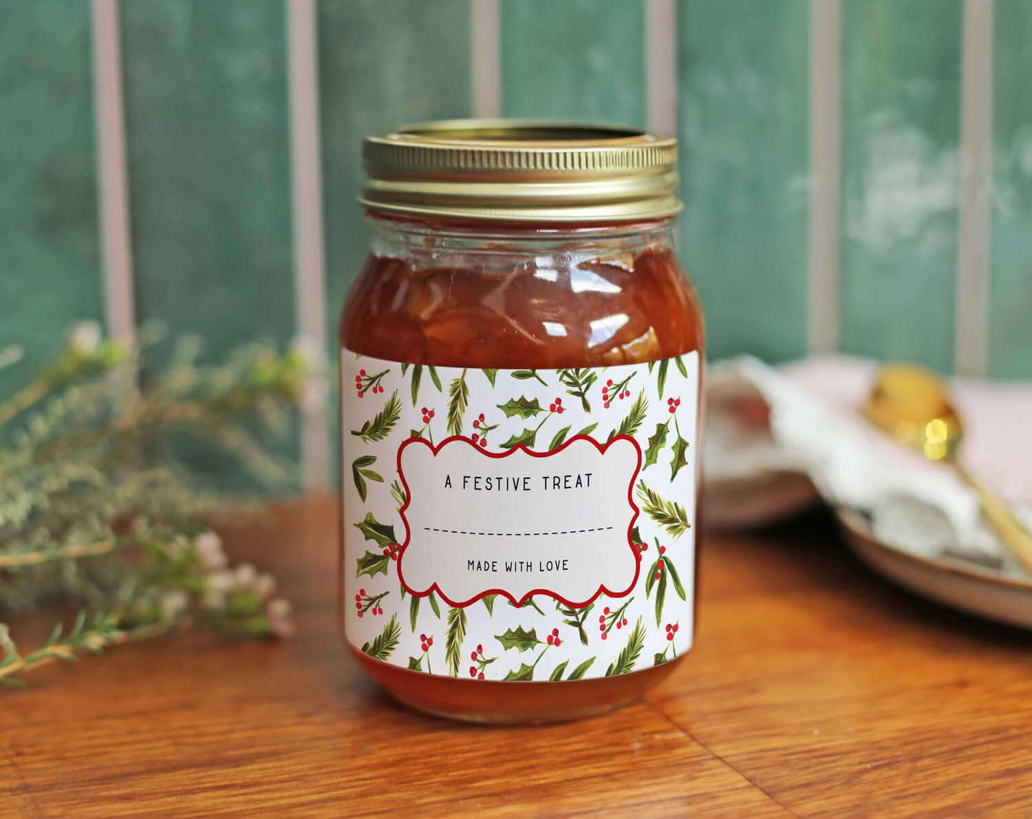 Christmas Jam Jar Labels With Holly on a jar featuring festive decorations and a gold lid, perfect for holiday gifts.