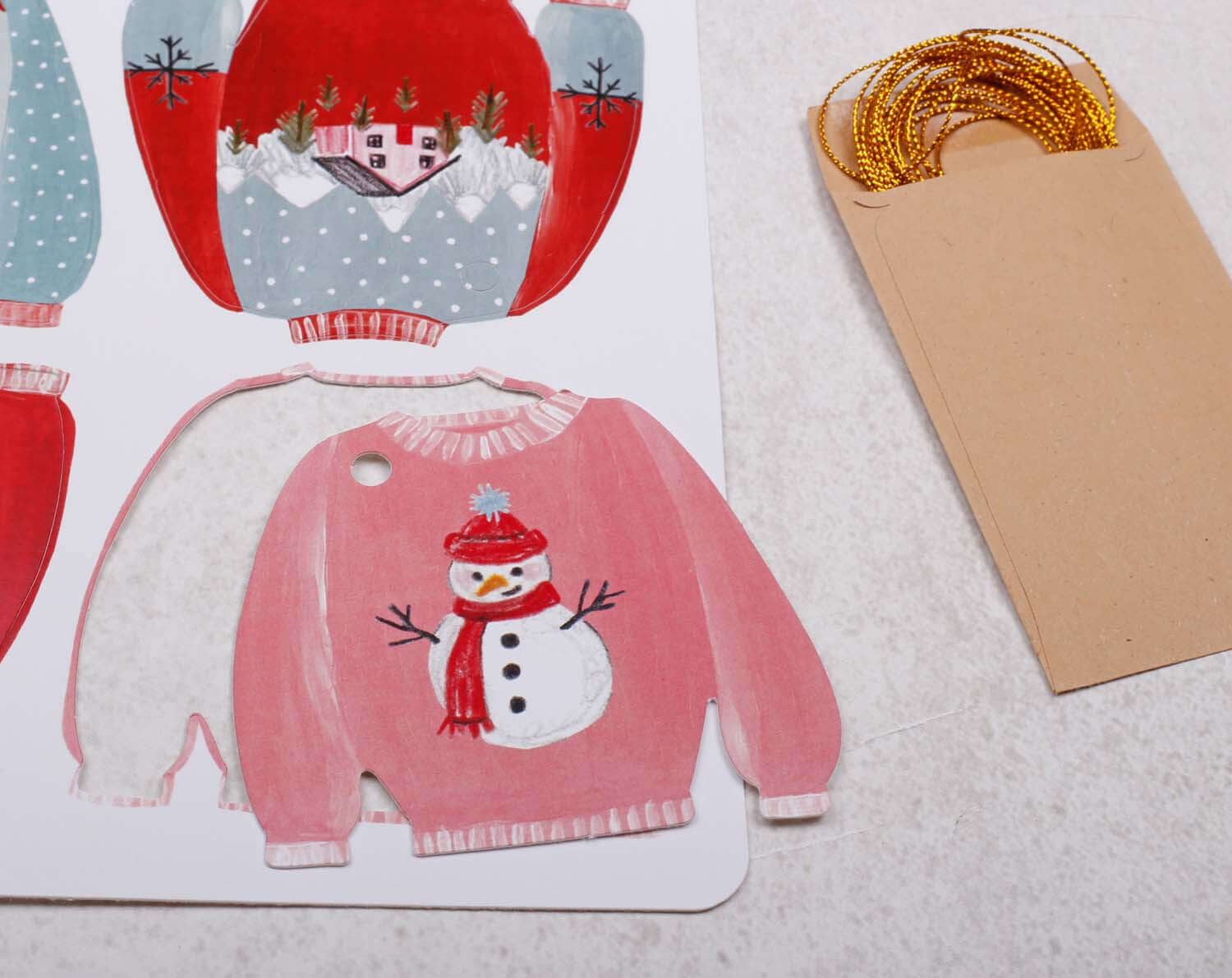 Colorful Christmas Jumper Gift Tags and gold twine, showcasing festive designs perfect for holiday gifts.