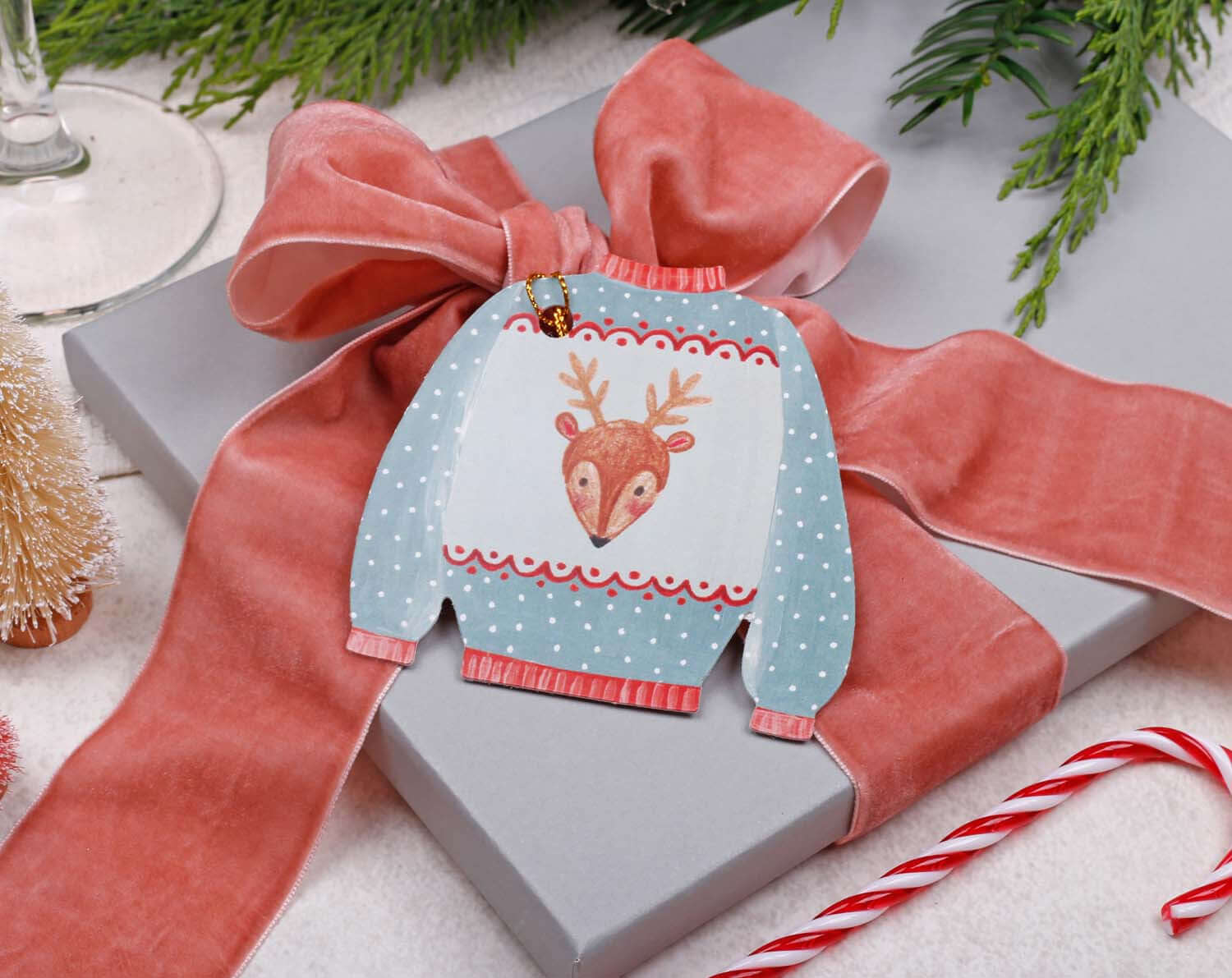 Christmas Jumper Gift Tags on a gift with a pink ribbon and candy cane for holiday wrapping.