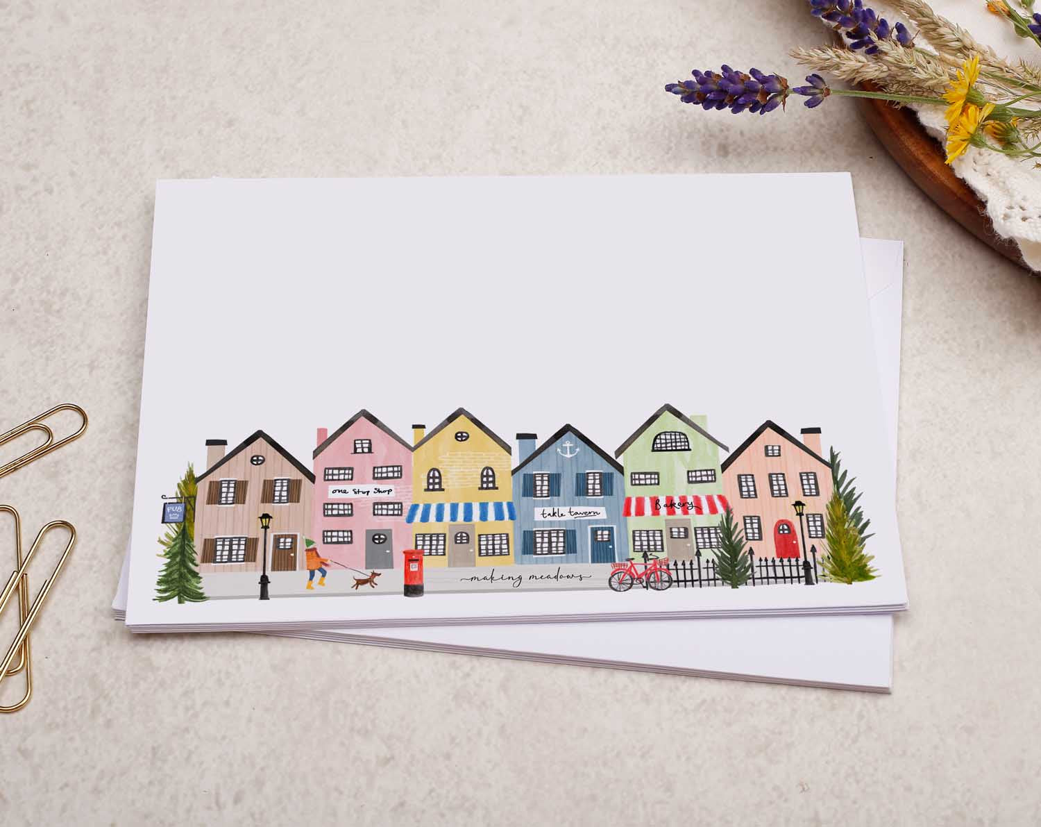 A pretty decorated C6 white envelope with a Cute Village Shops, Busy Street Design. 