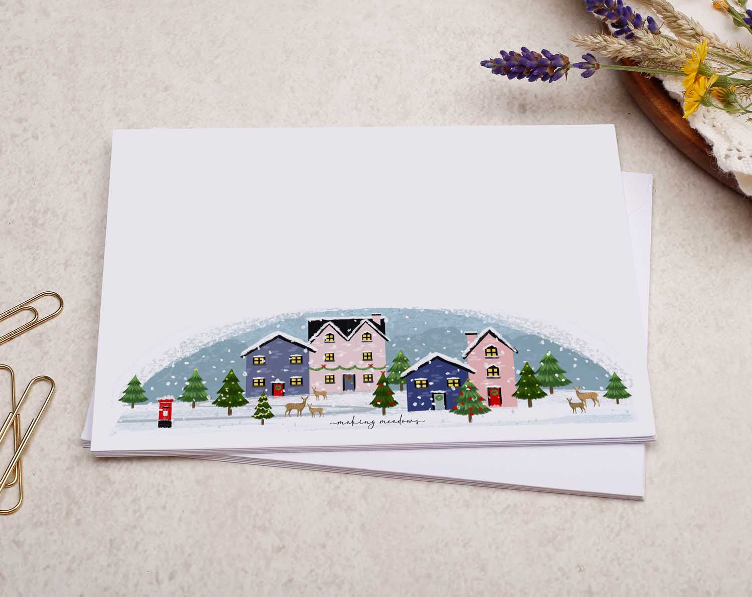 A pretty decorated C6 white envelope with a Festive Christmas Village Snow Design. 