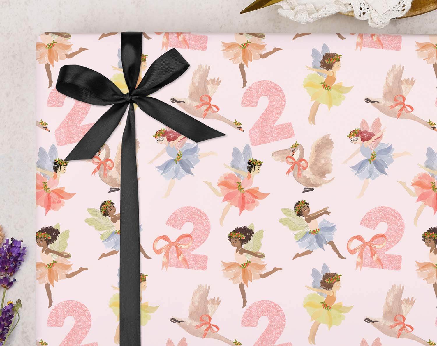 Fairy 2nd Birthday Wrapping Paper with a pink fairy pattern and black ribbon.