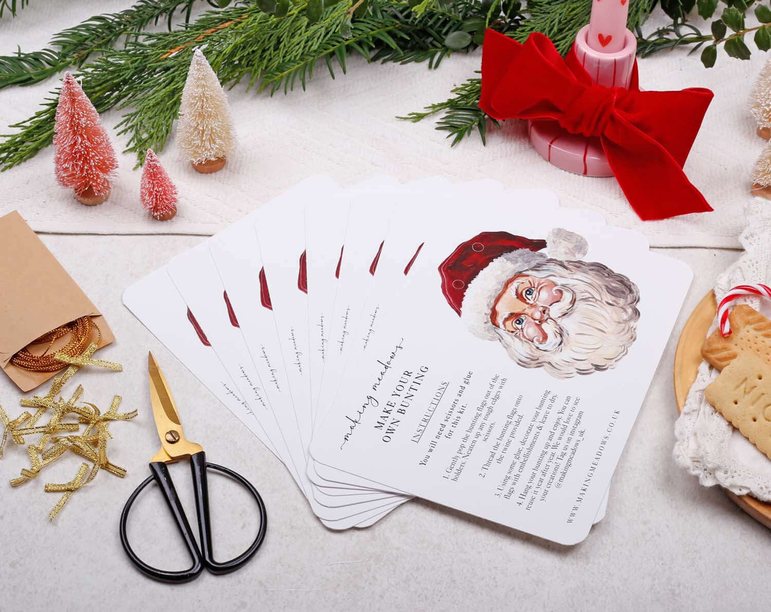 Father Christmas Bunting displayed with holiday decorations and scissors on a festive table.