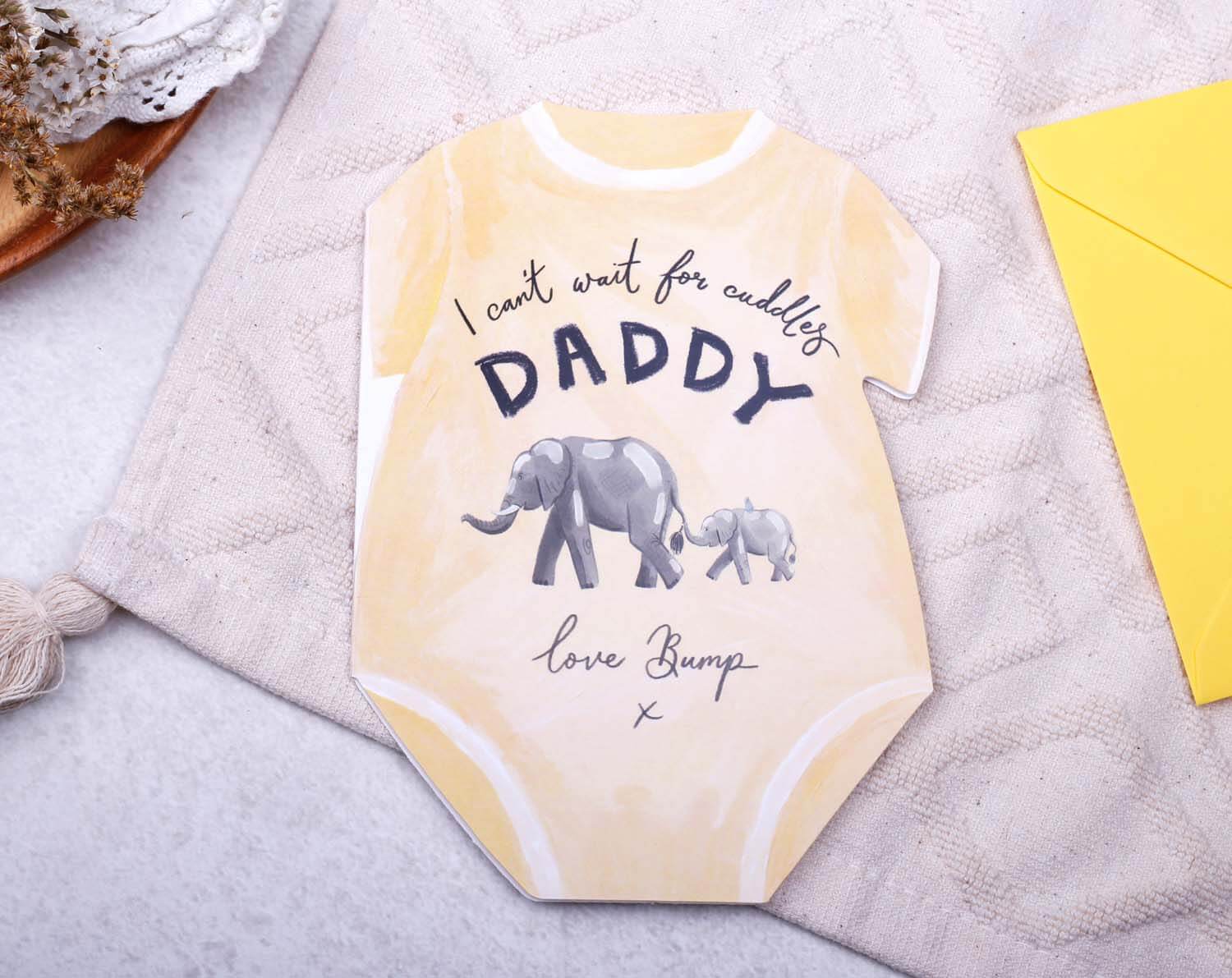 Father's Day From Bump Card designed as a yellow baby grow, featuring cute elephant graphics and the text 'I can't wait for cuddles Daddy'.