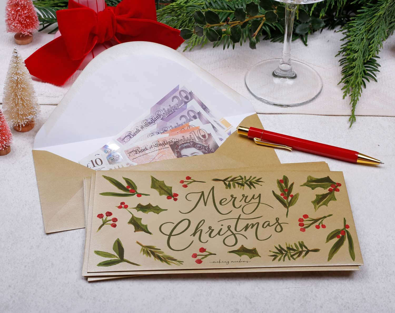 Foliage Christmas Money Envelopes with cash and festive design on a holiday table.