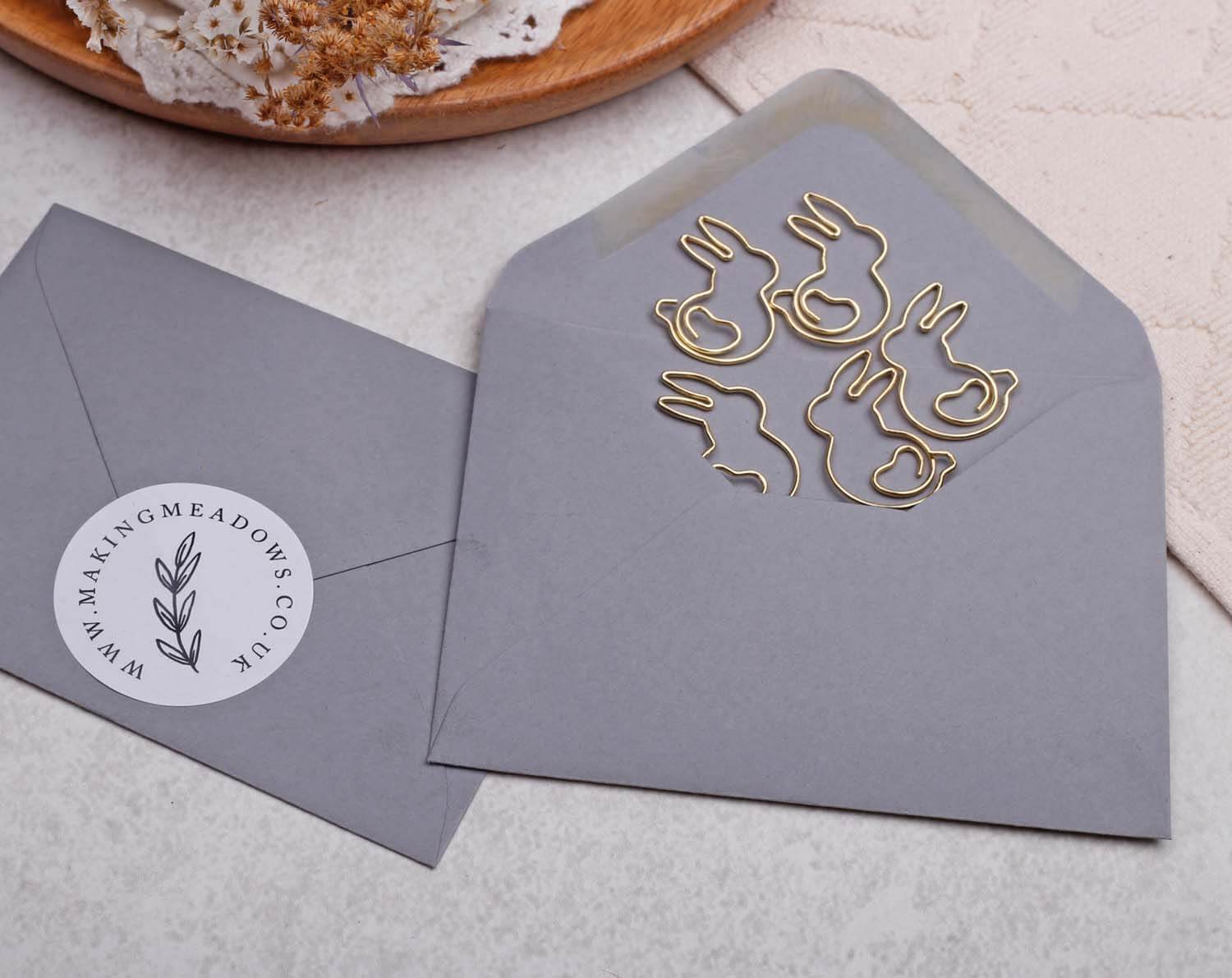 Gold Rabbit Paper Clips arranged inside a gray envelope, perfect for adding charm to stationery.