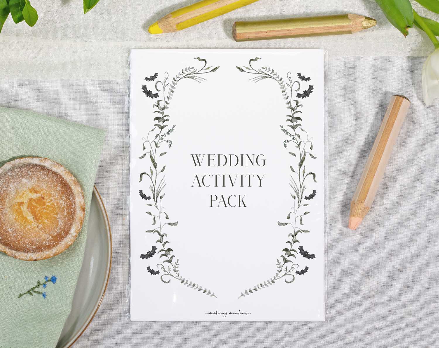 Gothic Wedding Kids Activity Pack on a table with coloring pencils and snacks, perfect for entertaining children at weddings.
