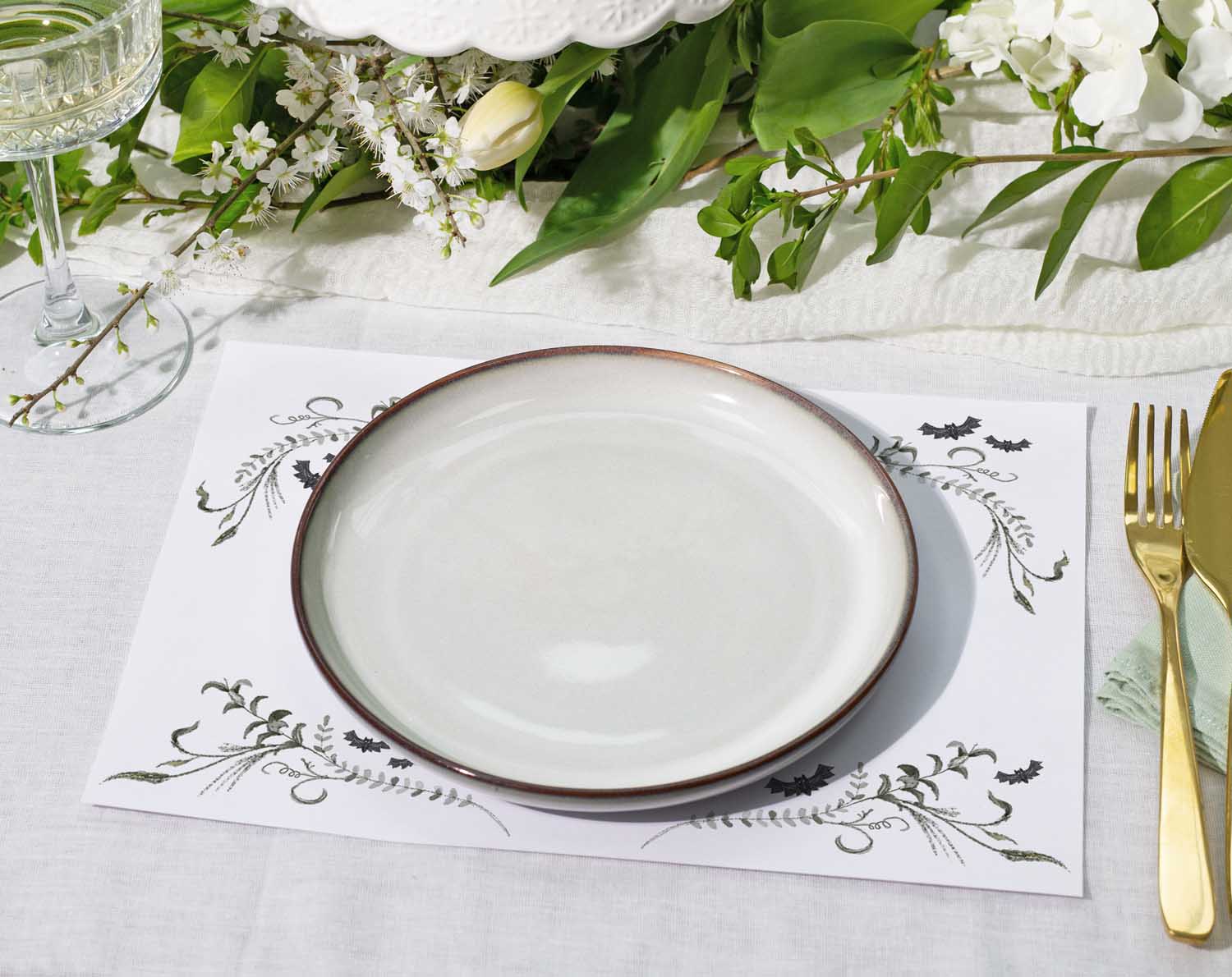 Gothic Wedding Placemats displayed on a table setting with a white plate and elegant greenery.