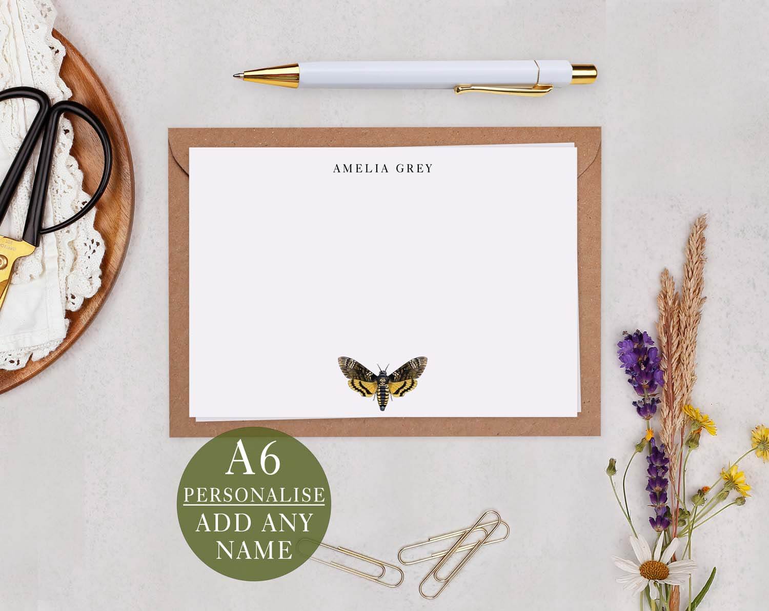 Hawk Moth Personalised Note cards on a table with a pen, scissors, and dried flowers for artistic stationery.