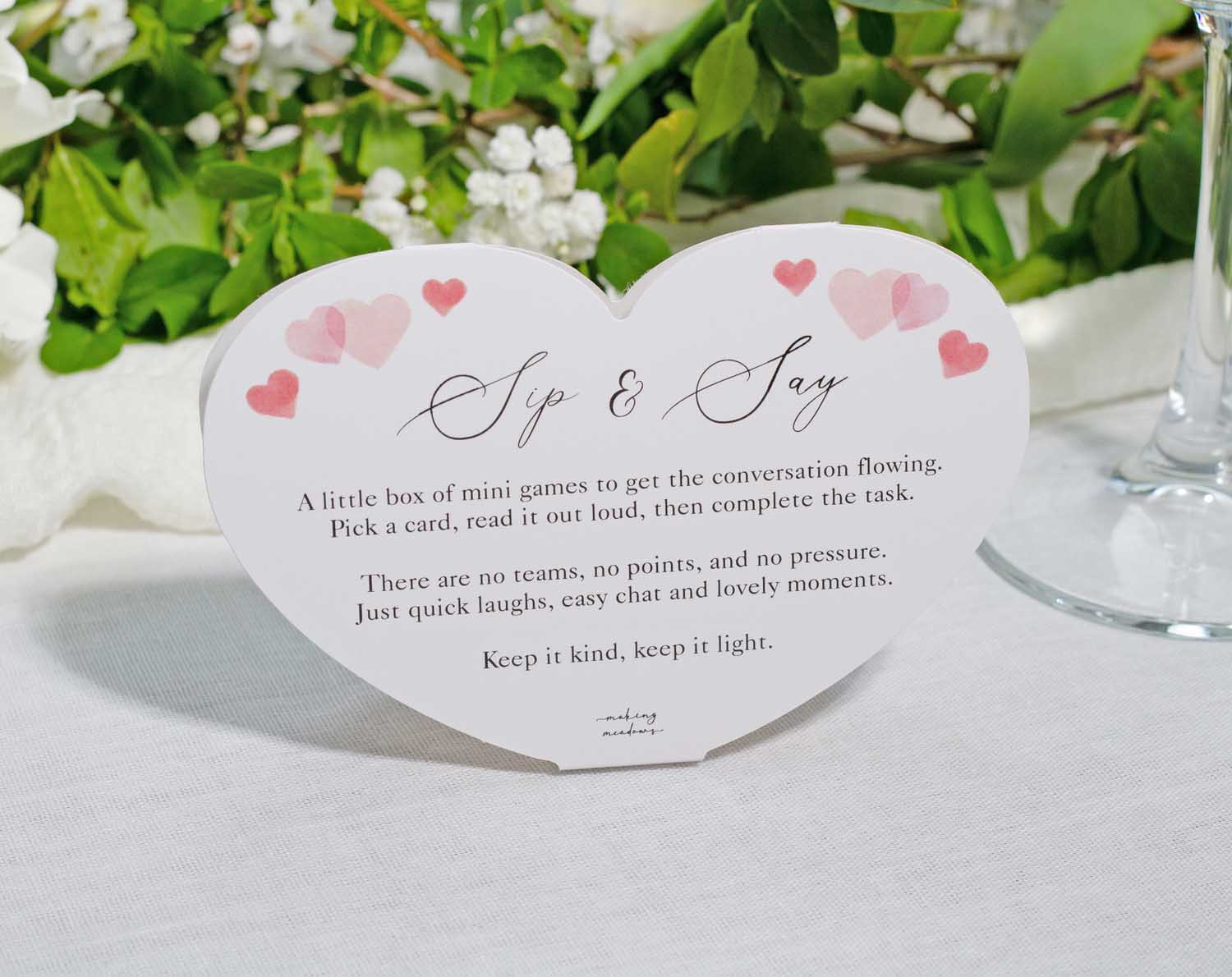 Heart Wedding Table Game Sip & Say card with instructions on mini games for wedding guests.
