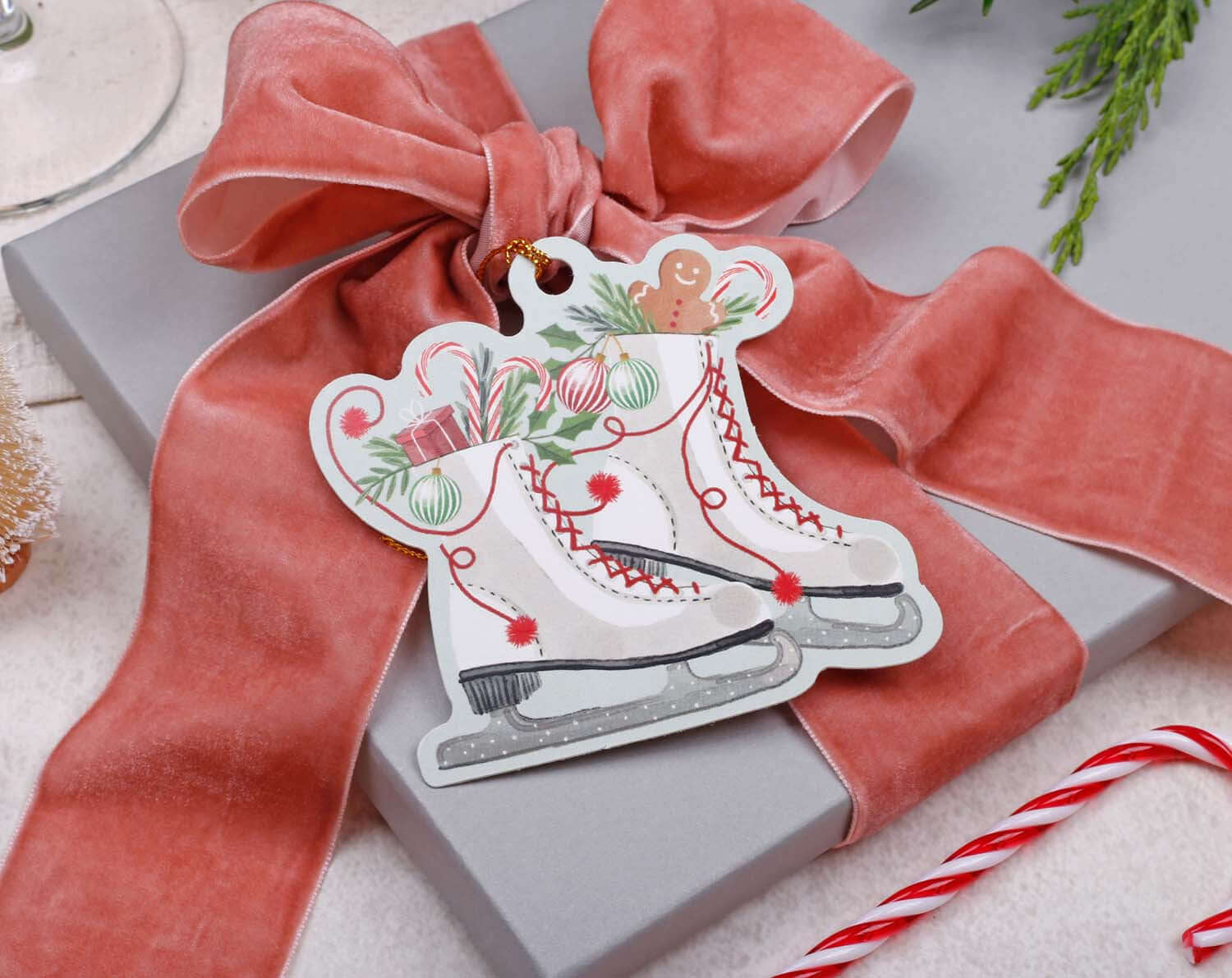 Ice Skating Christmas Gift Tags displayed on a gift wrapped with a pink ribbon.