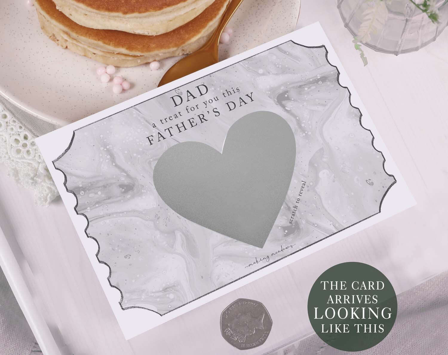 Marble Scratch To Reveal Card For Dad displayed on a table with pancakes, featuring a scratch heart and Father's Day message.