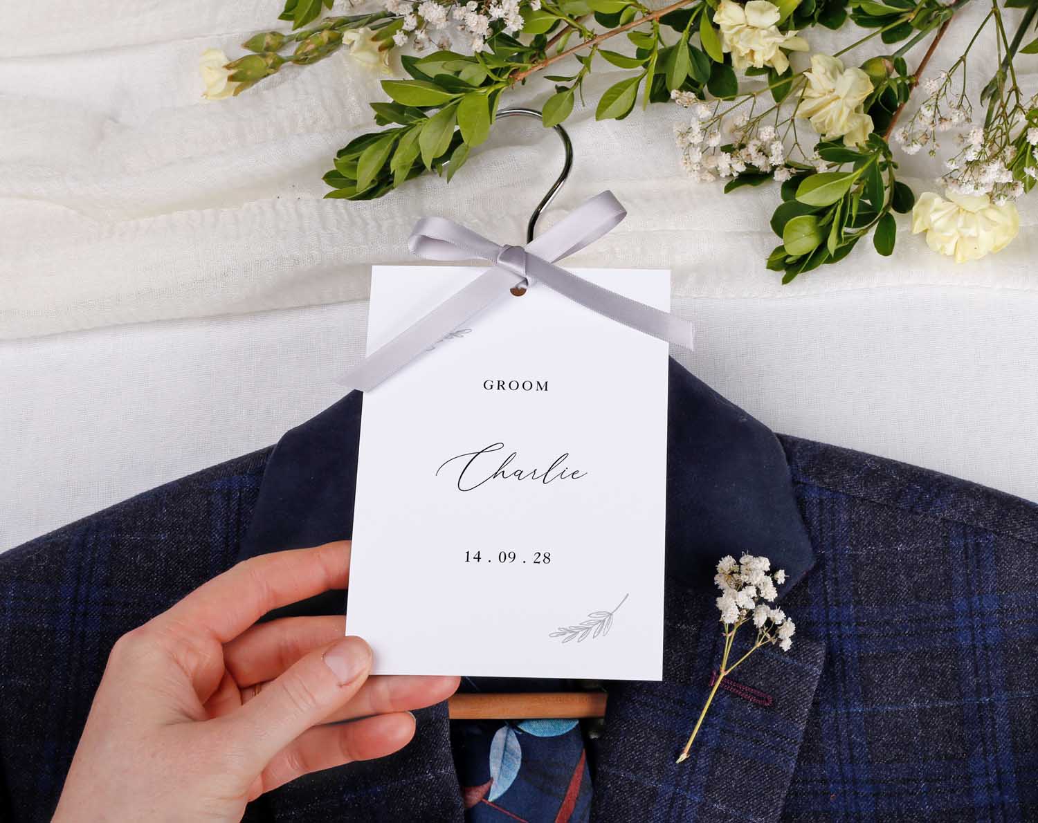 Minimalist Wedding Hanger Tags for Bridal Party with groom tag and floral arrangement.
