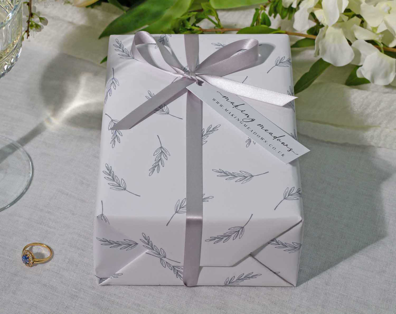 Minimalist Wedding Wrapping Paper featuring elegant leaf designs and a satin ribbon on a beautifully wrapped gift.