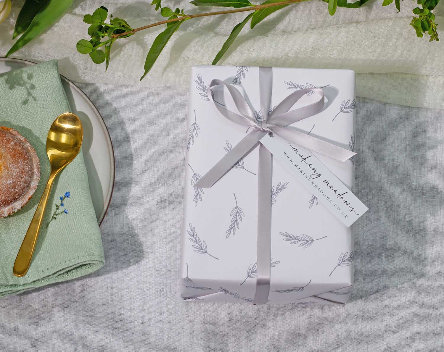 Minimalist Wedding Wrapping Paper beautifully presented with a silver ribbon and tag on a light, natural background.