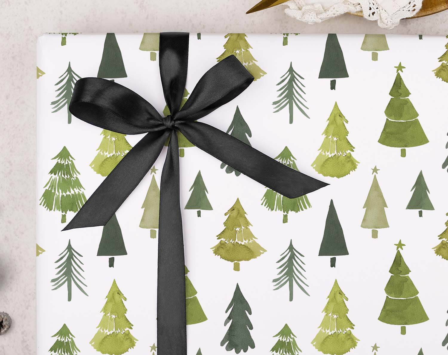 Modern Christmas Tree Wrapping Paper featuring green trees and a black bow on a beautifully wrapped gift.