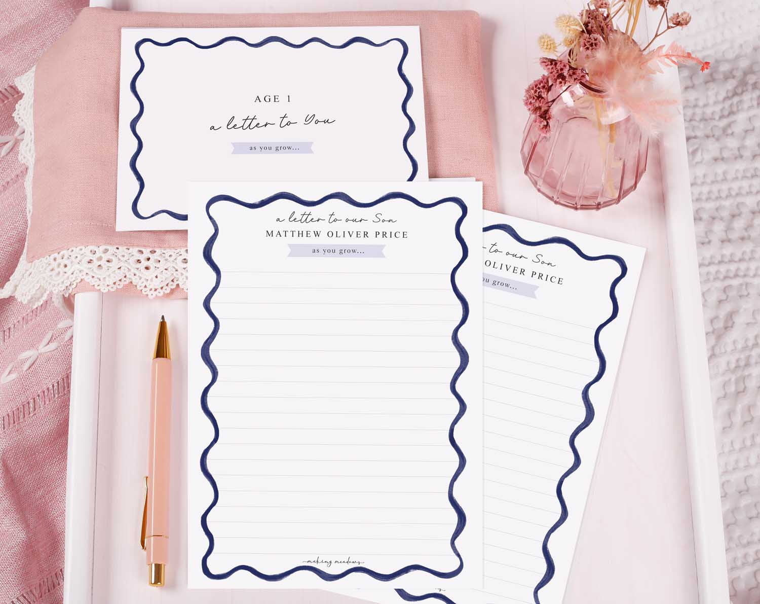 Personalised Blue Wavy Letter To Our Son displayed with personalized writing paper and pen on a soft pink background.