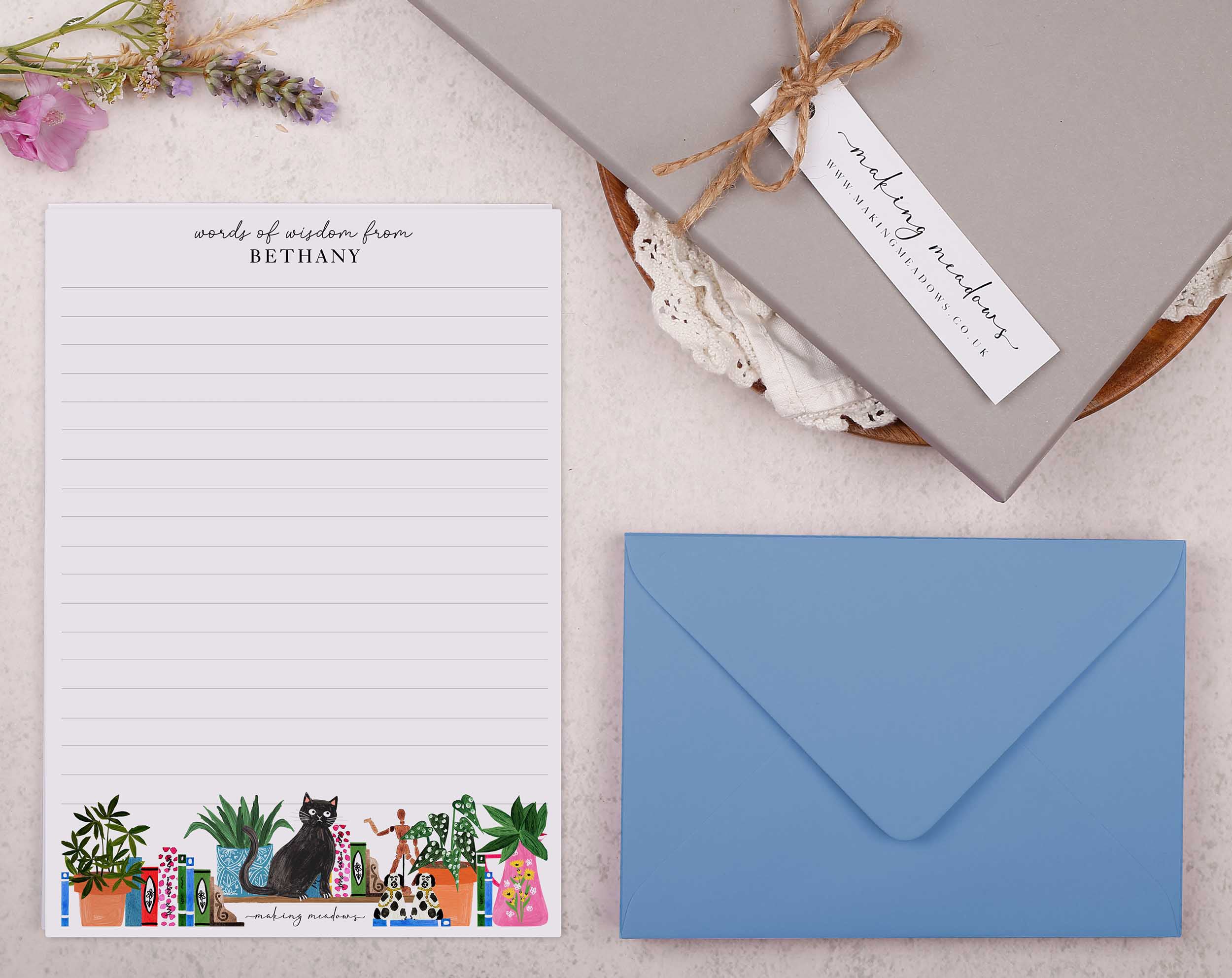 Premium personalised A5 letter writing paper set with a cheeky black cat and a bookcase bursting with books and trinkets.