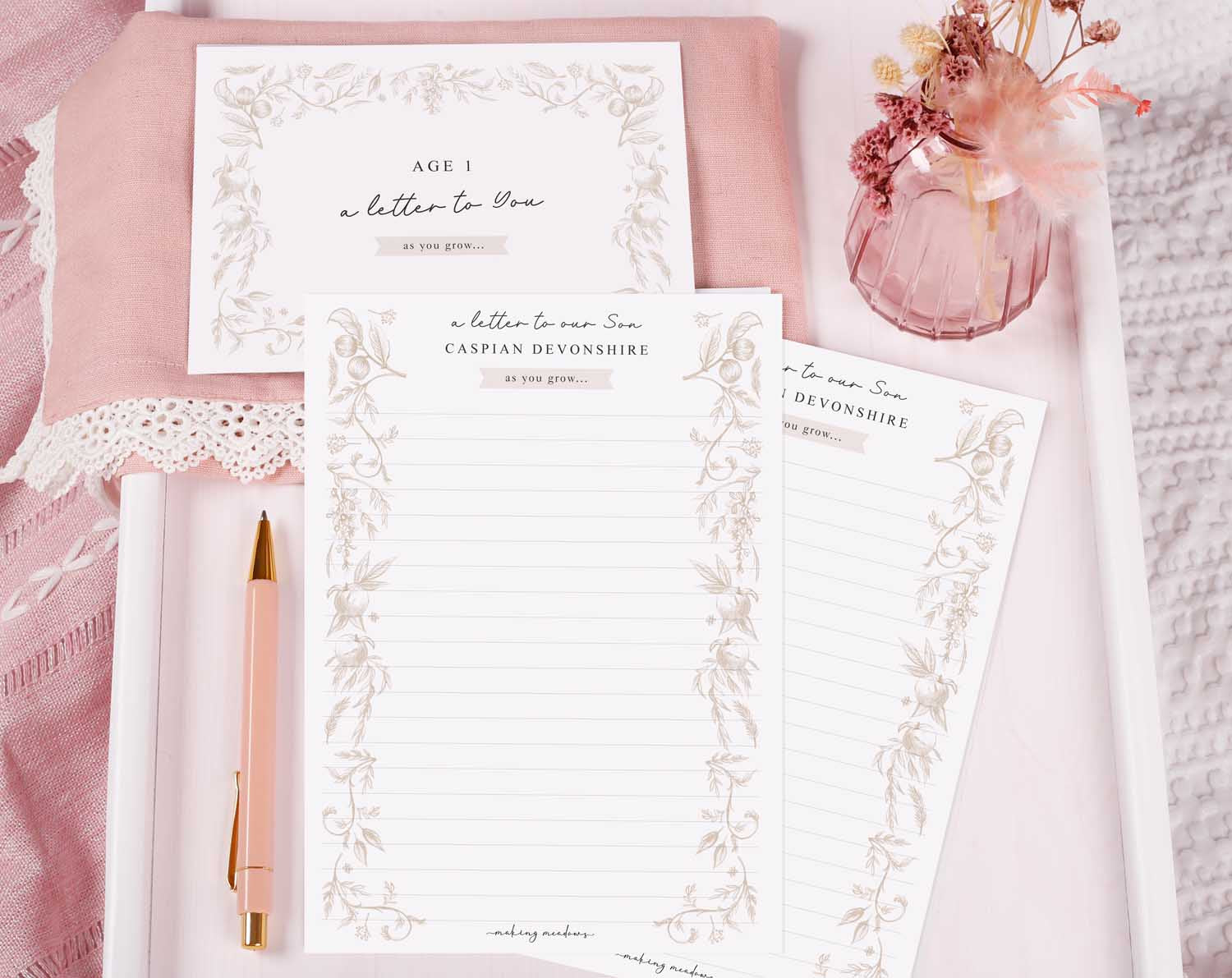 Personalised Neutral Letter To Our Son letter writing paper with floral design and pen on a pink background.