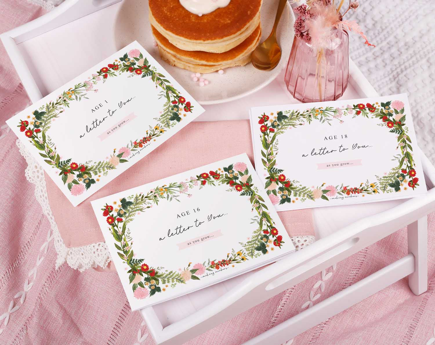 Personalised Wild Floral Letter To Our Daughter displayed on a tray with pancakes and pink decor.