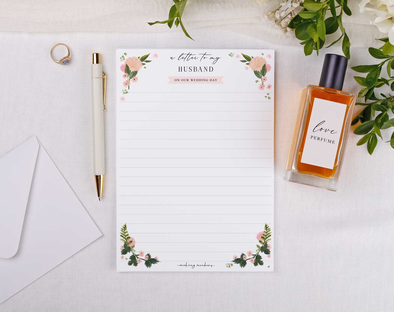 Pink Floral Wedding Letter to My Husband with floral design on lined stationery, pen, perfume, and ring.