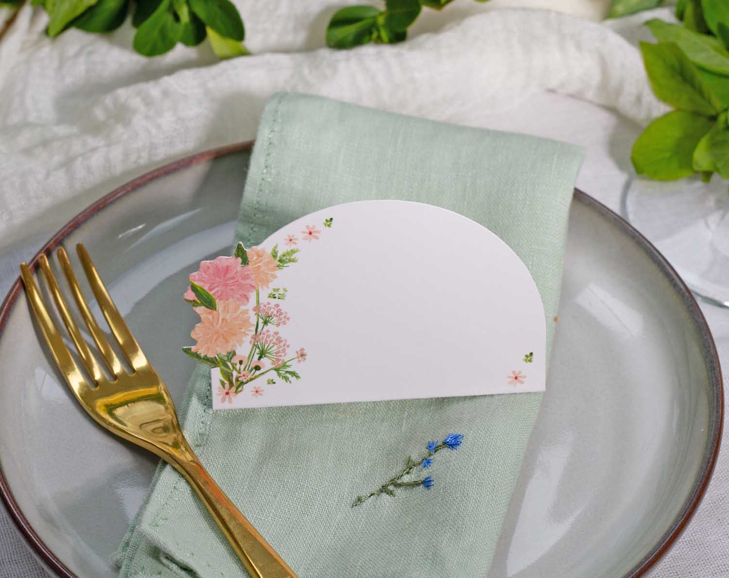 Pink Floral Wedding Place Cards elegantly displayed on a green napkin, enhancing a romantic table setting.
