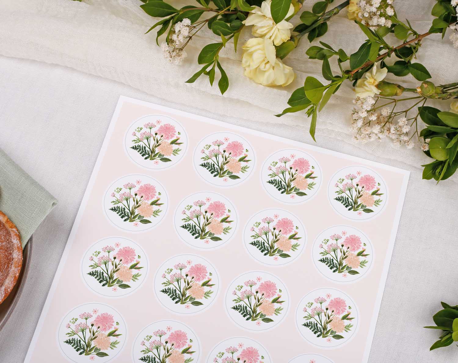 Pink Floral Wedding Stickers on a sheet surrounded by greenery and floral decor.