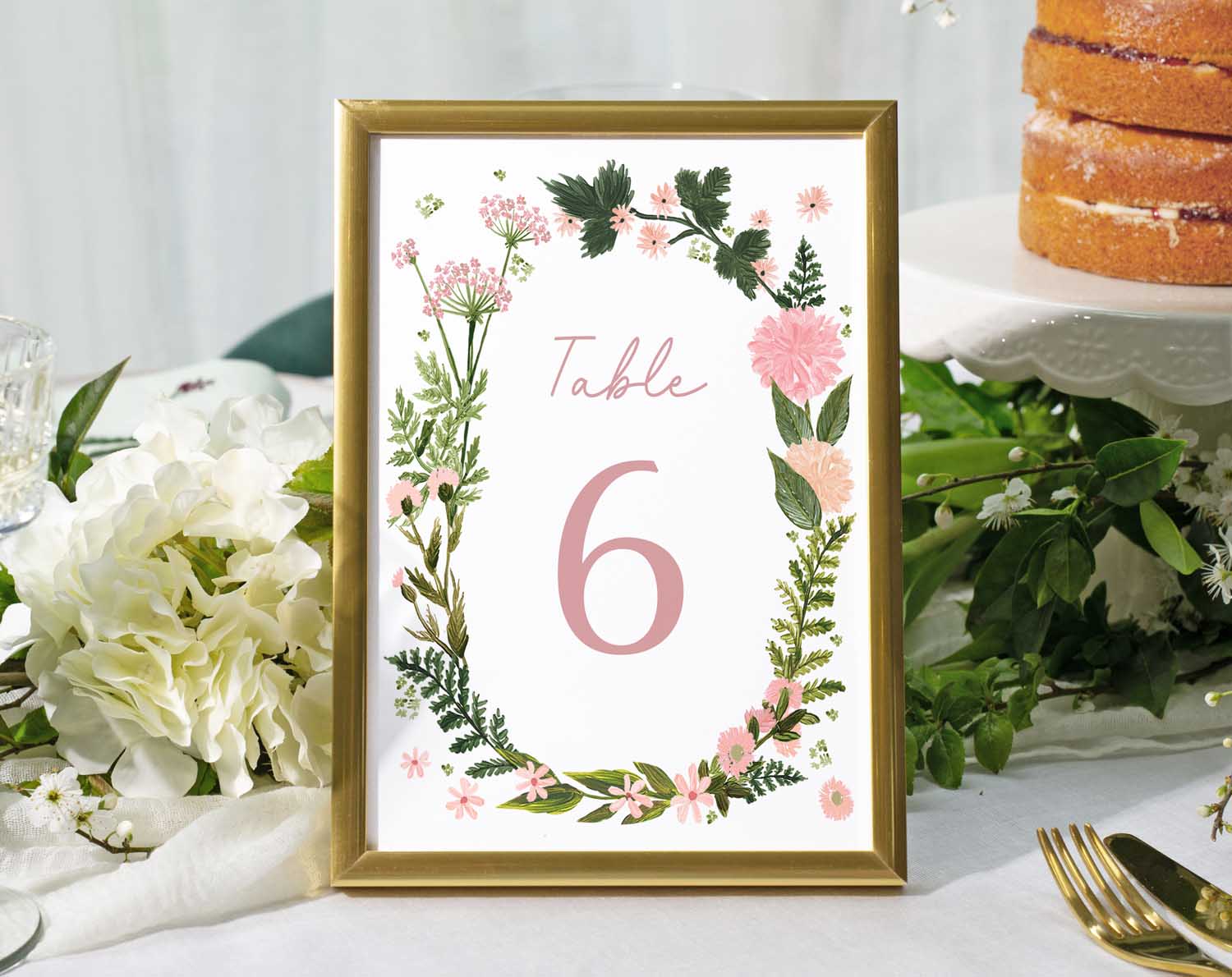 Pink Floral Wedding Table Numbers featuring a framed table number six surrounded by flowers on a reception table.
