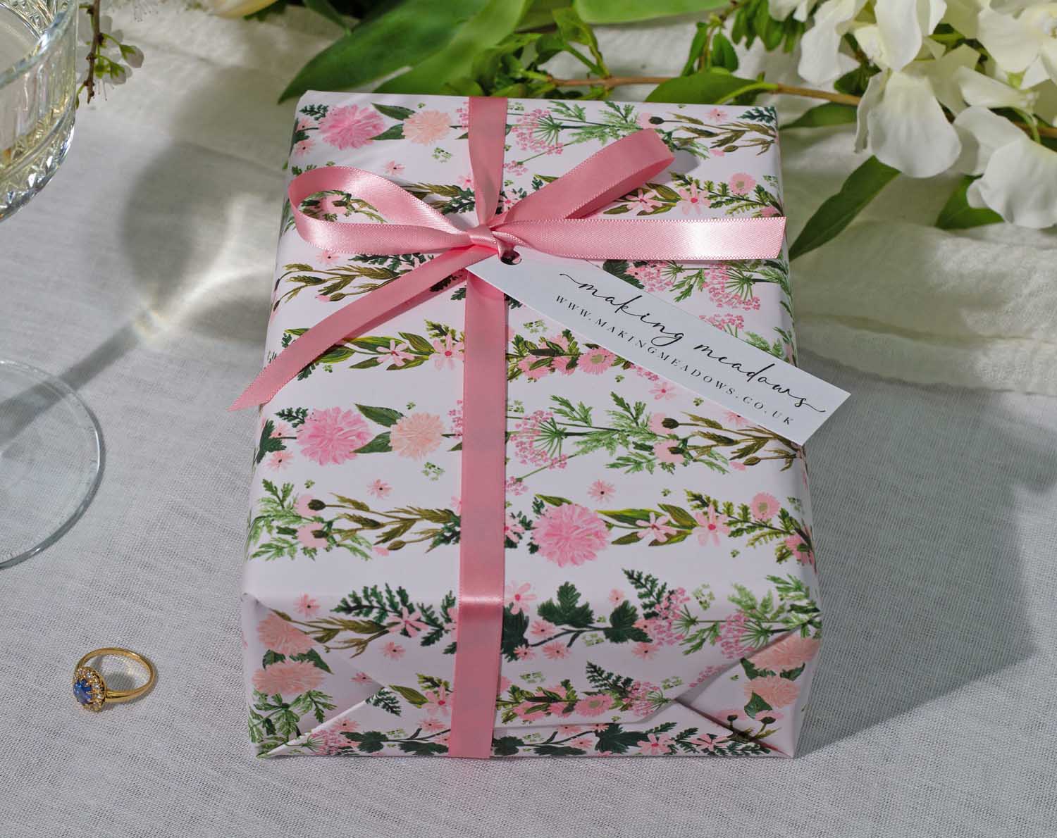Pink Floral Wedding Wrapping Paper beautifully decorated gift with a pink ribbon and floral design, perfect for weddings.