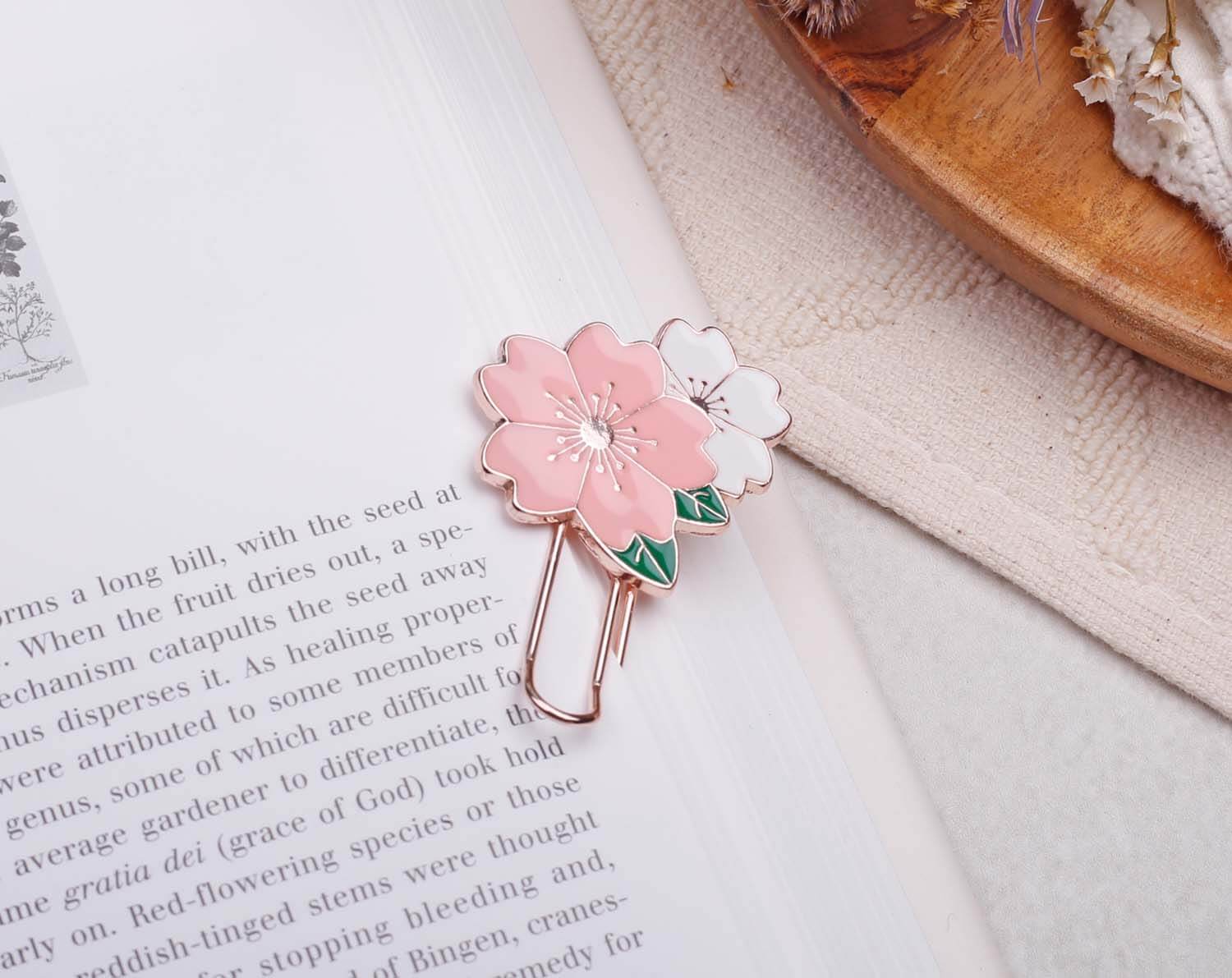 Pink Flower Paper Clips - Enamel attached to a book page, featuring beautiful pink and white flower designs on a rose gold clip.